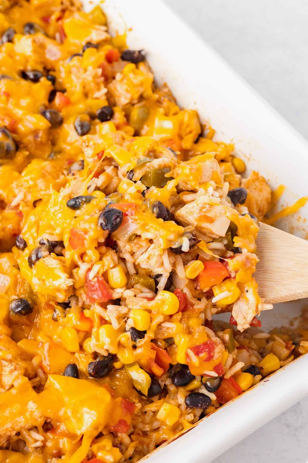 Fiesta Chicken Casserole is a hearty chicken and rice casserole loaded with diced bell peppers, Rotel, black beans, corn and cheddar cheese.