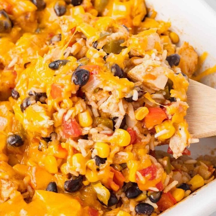 Fiesta Chicken Casserole is a hearty chicken and rice casserole loaded with diced bell peppers, Rotel, black beans, corn and cheddar cheese.