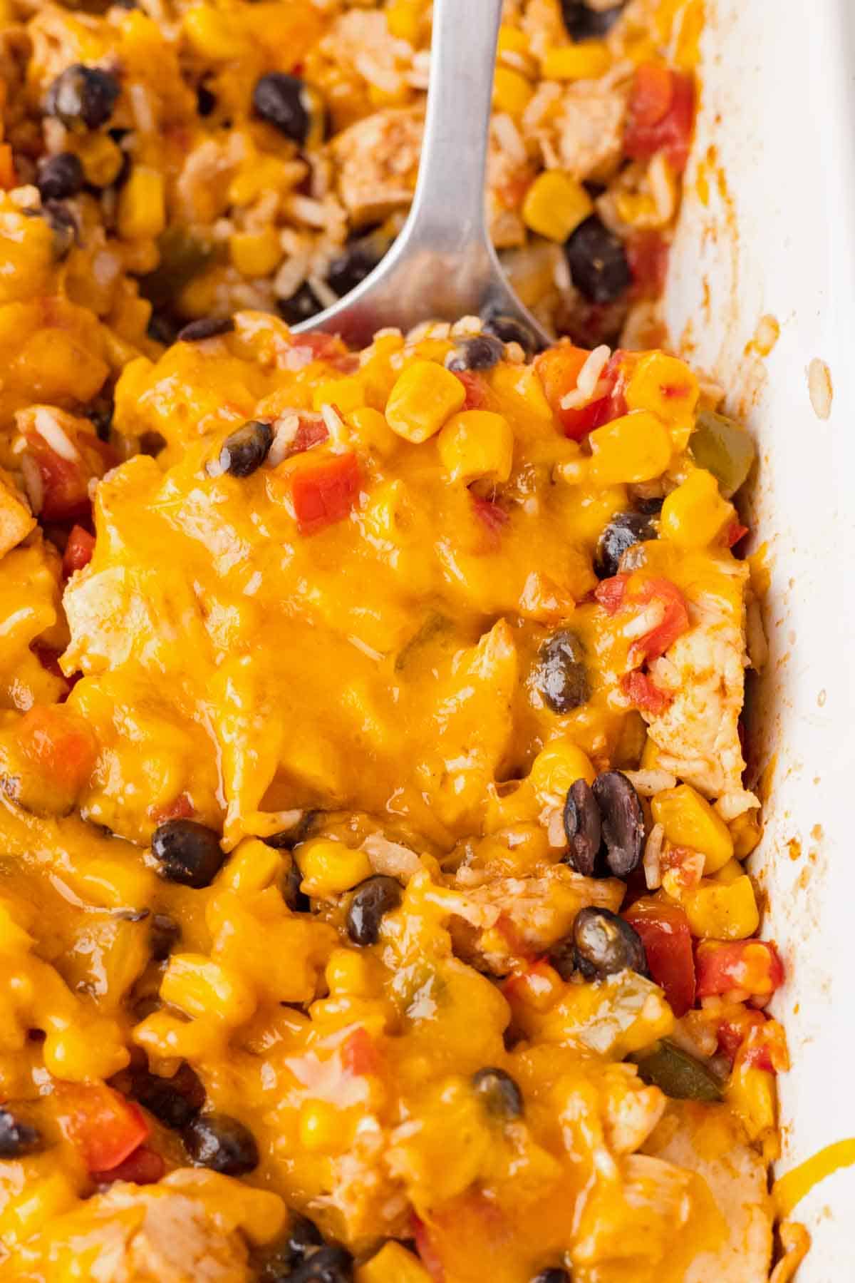 Fiesta Chicken Casserole is a hearty chicken and rice casserole loaded with diced bell peppers, Rotel, black beans, corn and cheddar cheese.