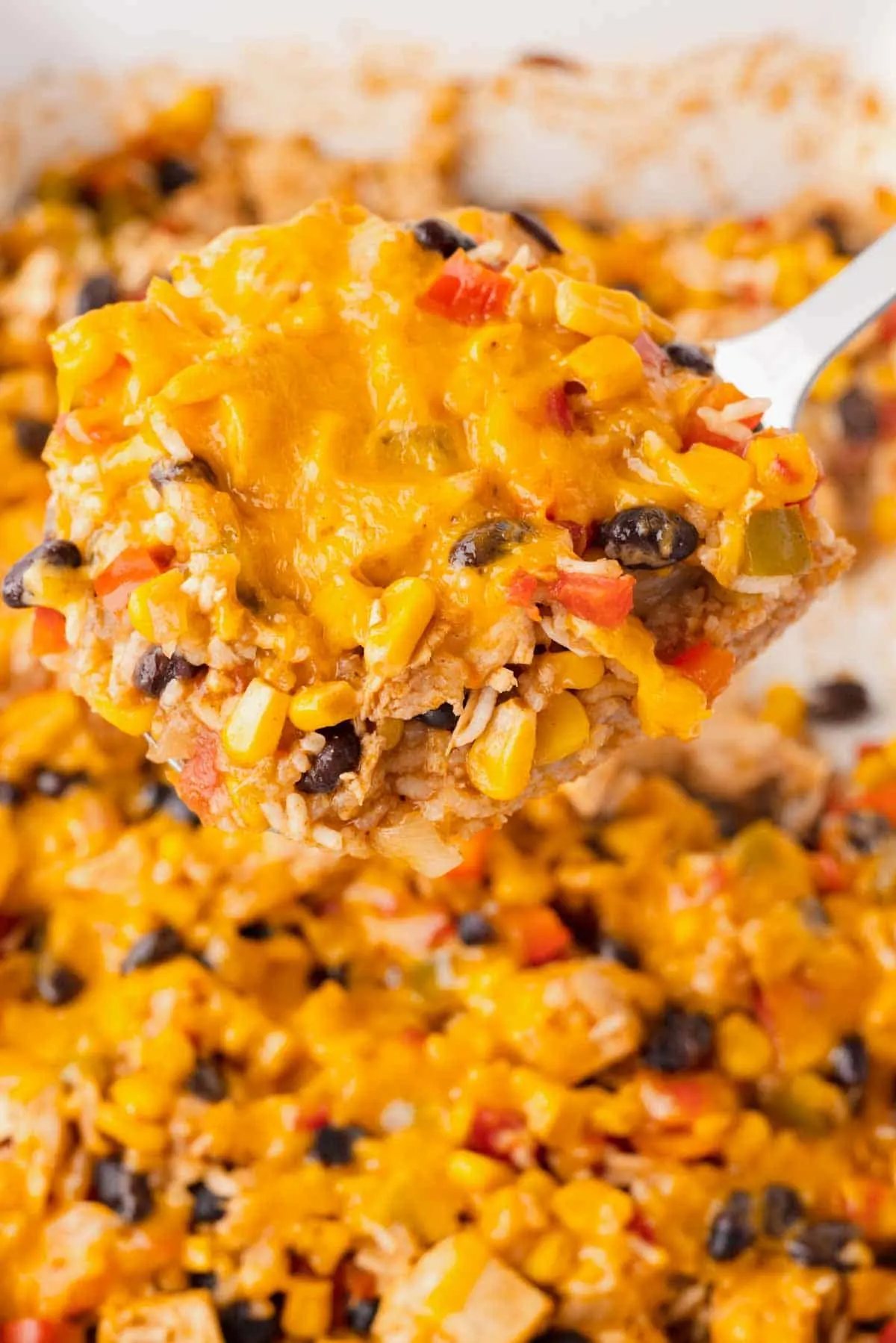 Fiesta Chicken Casserole is a hearty chicken and rice casserole loaded with diced bell peppers, Rotel, black beans, corn and cheddar cheese.