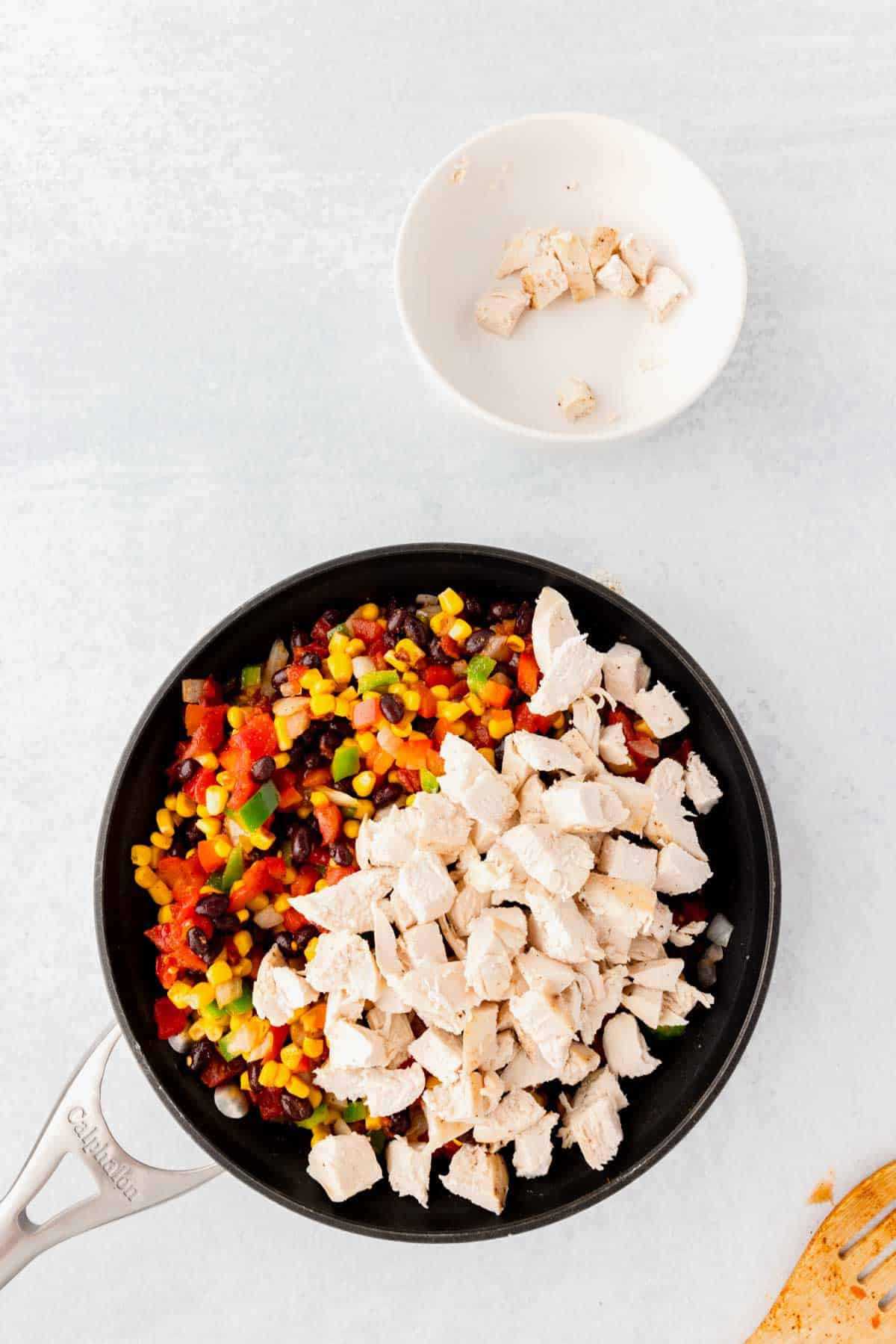 cooked chicken chunks added to skillet with vegetable mixture