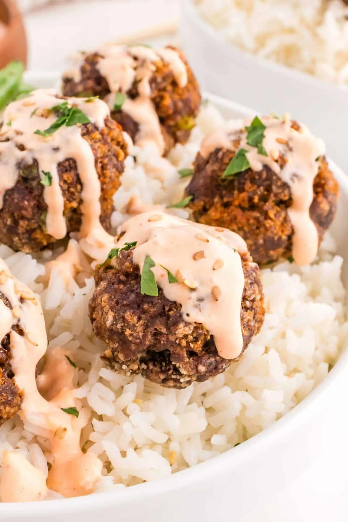 Firecracker Meatballs are flavourful homemade ground beef meatballs with a bit of a kick from siracha sauce and red pepper flakes and topped with a sour cream and mayo based sauce.