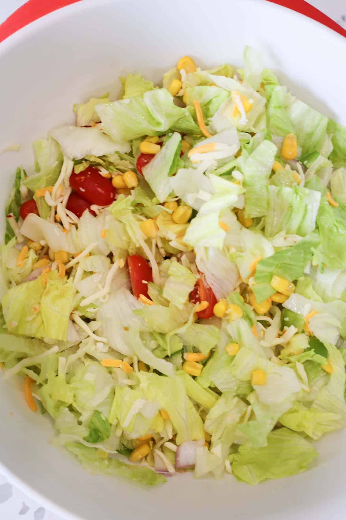 taco salad ingredients tossed in a bowl