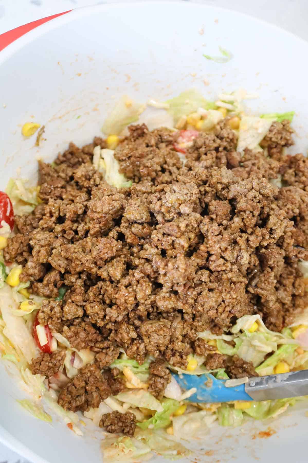 ground beef added to bowl with taco salad