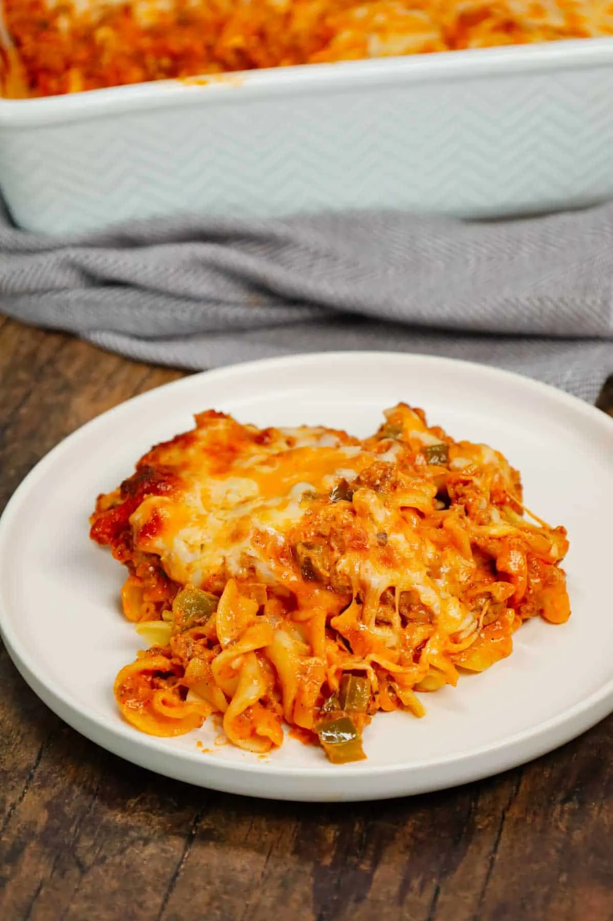 Grandma's Ground Beef Casserole is a simple and classic hamburger dish made with egg noodles, condensed tomato soup, onions, green bell peppers and cream cheese all baked with shredded mozzarella and cheddar on top.