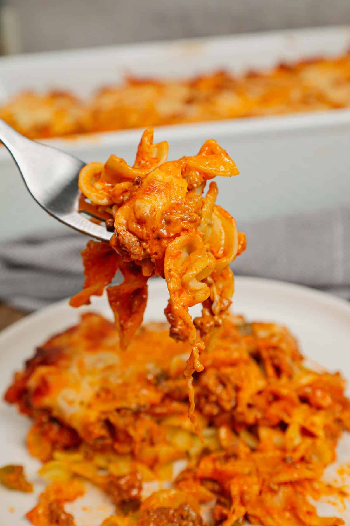 Grandma's Ground Beef Casserole is a simple and classic hamburger dish made with egg noodles, condensed tomato soup, onions, green bell peppers and cream cheese all baked with shredded mozzarella and cheddar on top.