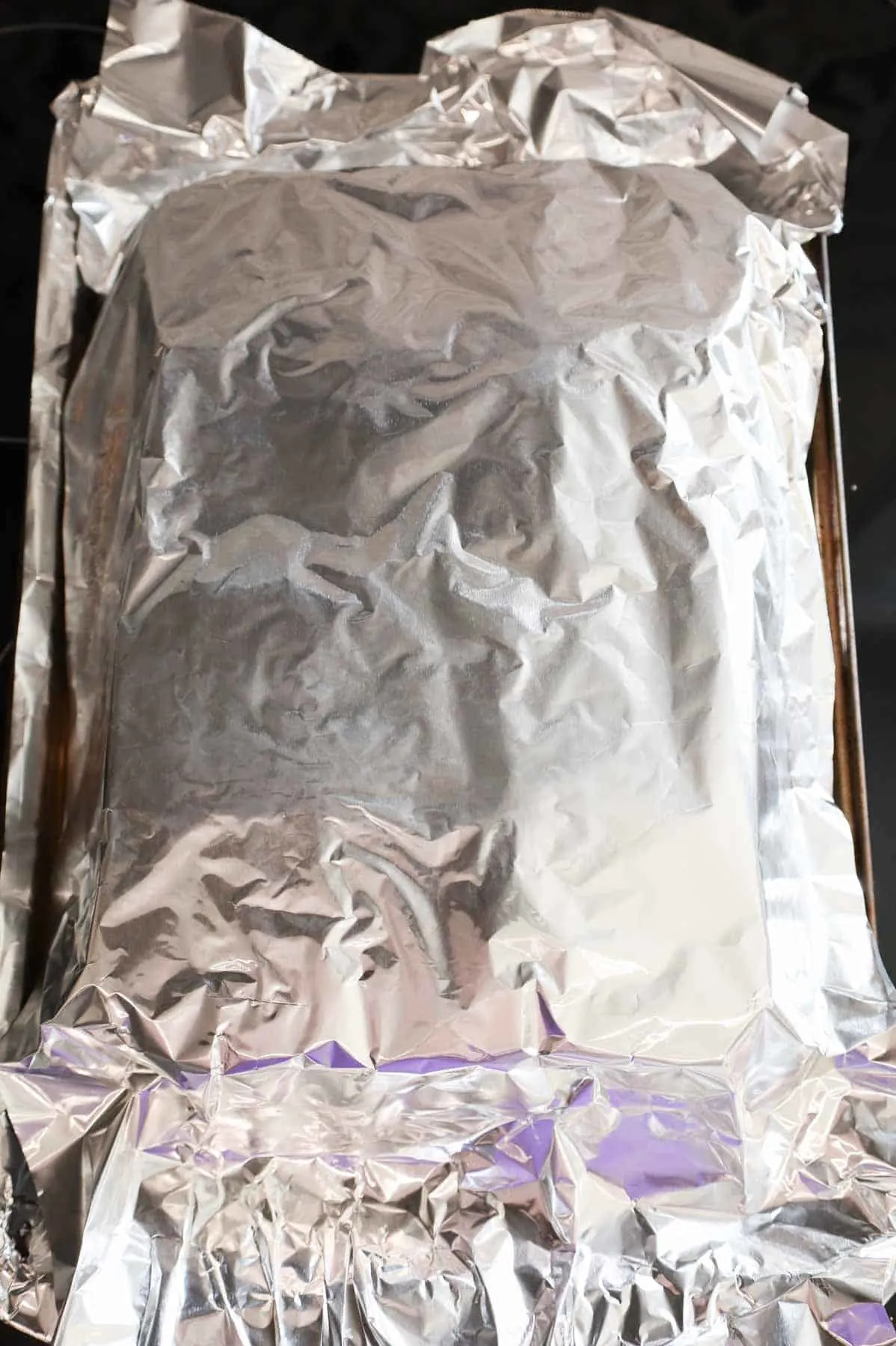 foil covered sliders on a baking sheet
