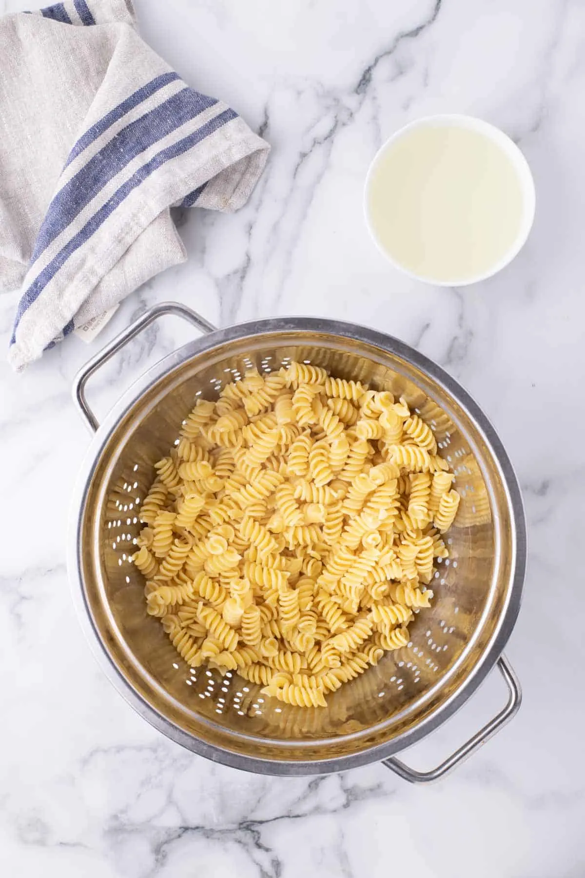 cooked rotini noodles in a colander