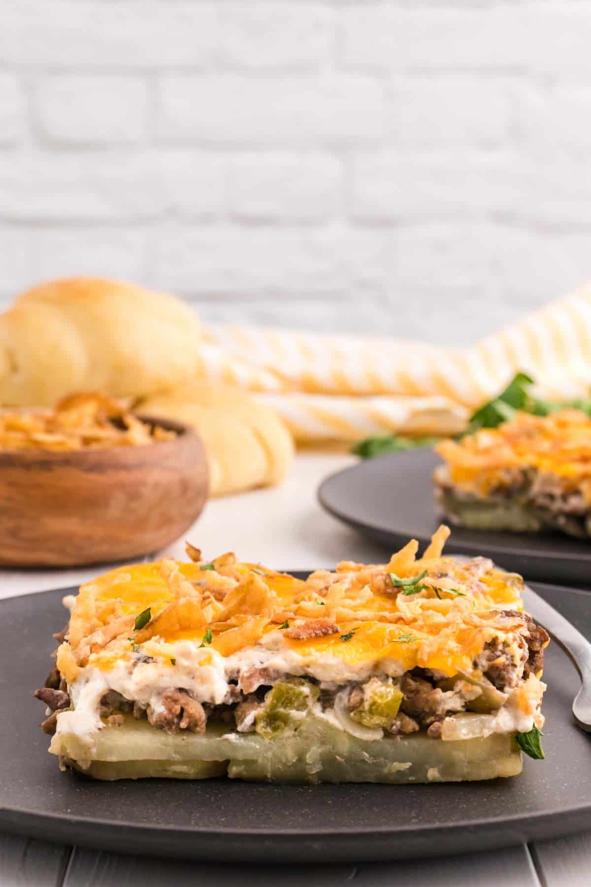 Hobo Casserole is a layered ground beef and sliced potato casserole loaded with diced bell peppers, onions, sour cream, cream of mushroom soup, cheddar cheese and French's crispy fried onions.