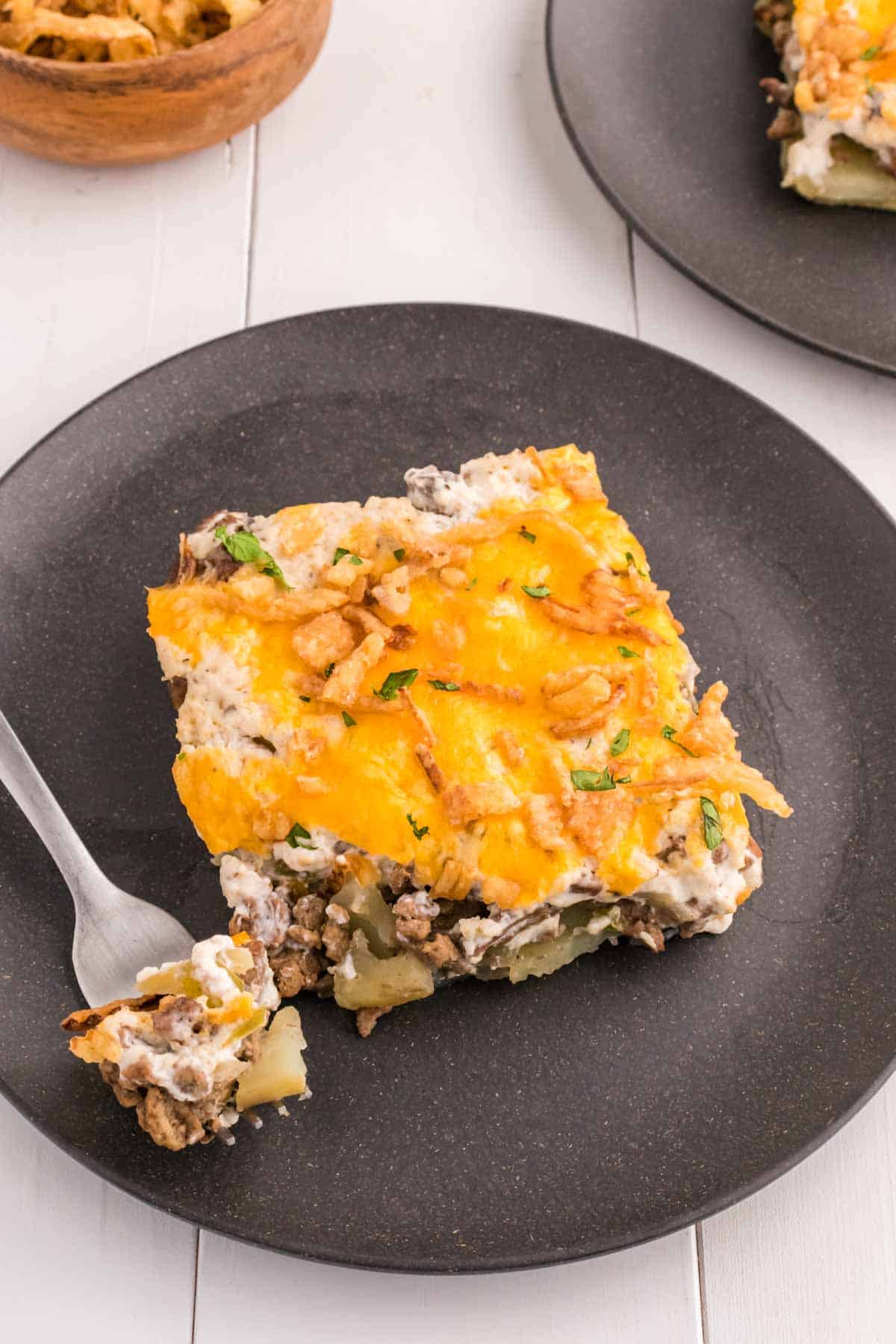 Hobo Casserole is a layered ground beef and sliced potato casserole loaded with diced bell peppers, onions, sour cream, cream of mushroom soup, cheddar cheese and French's crispy fried onions.