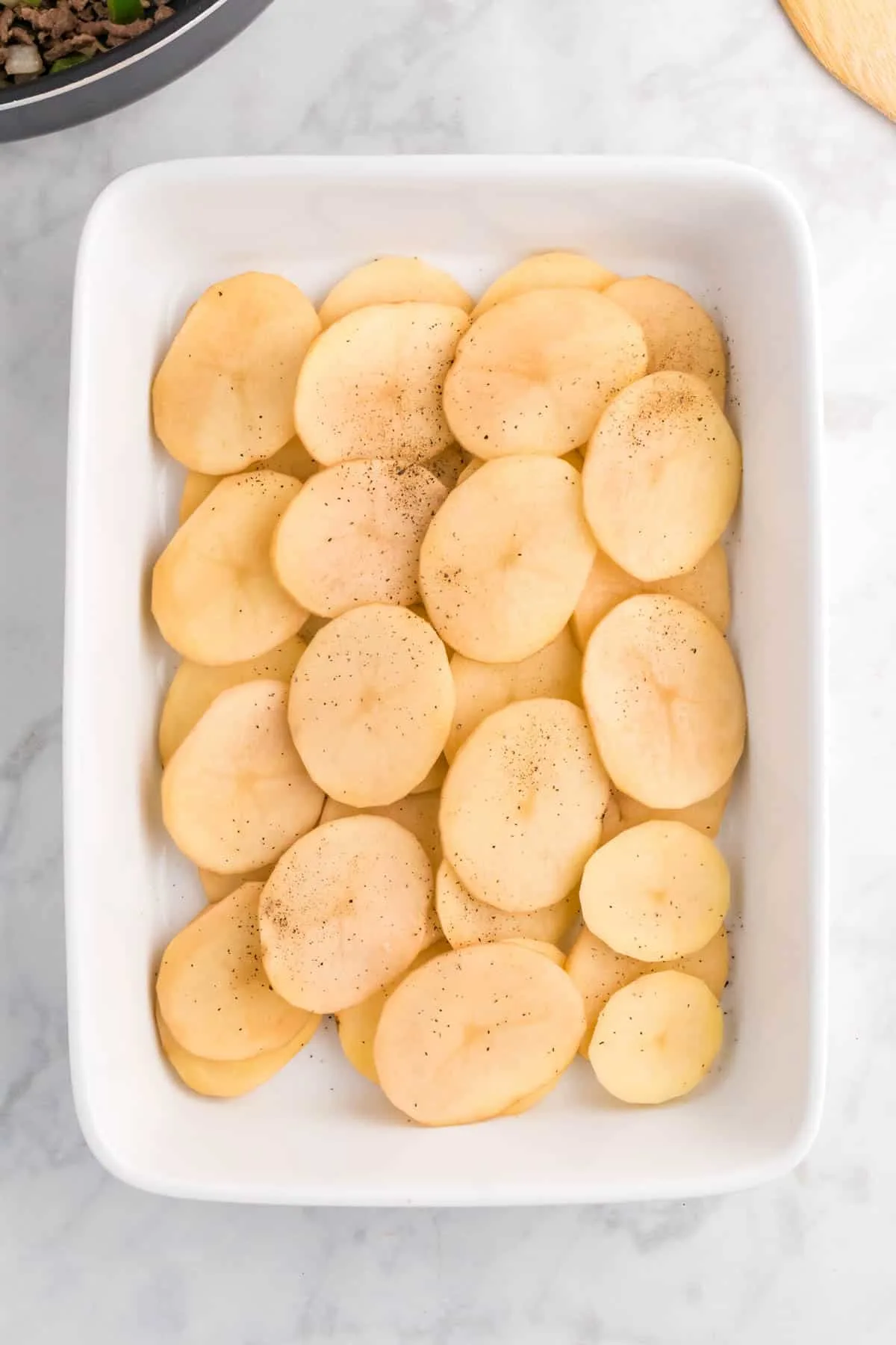 layers of sliced potatoes in a baking dish