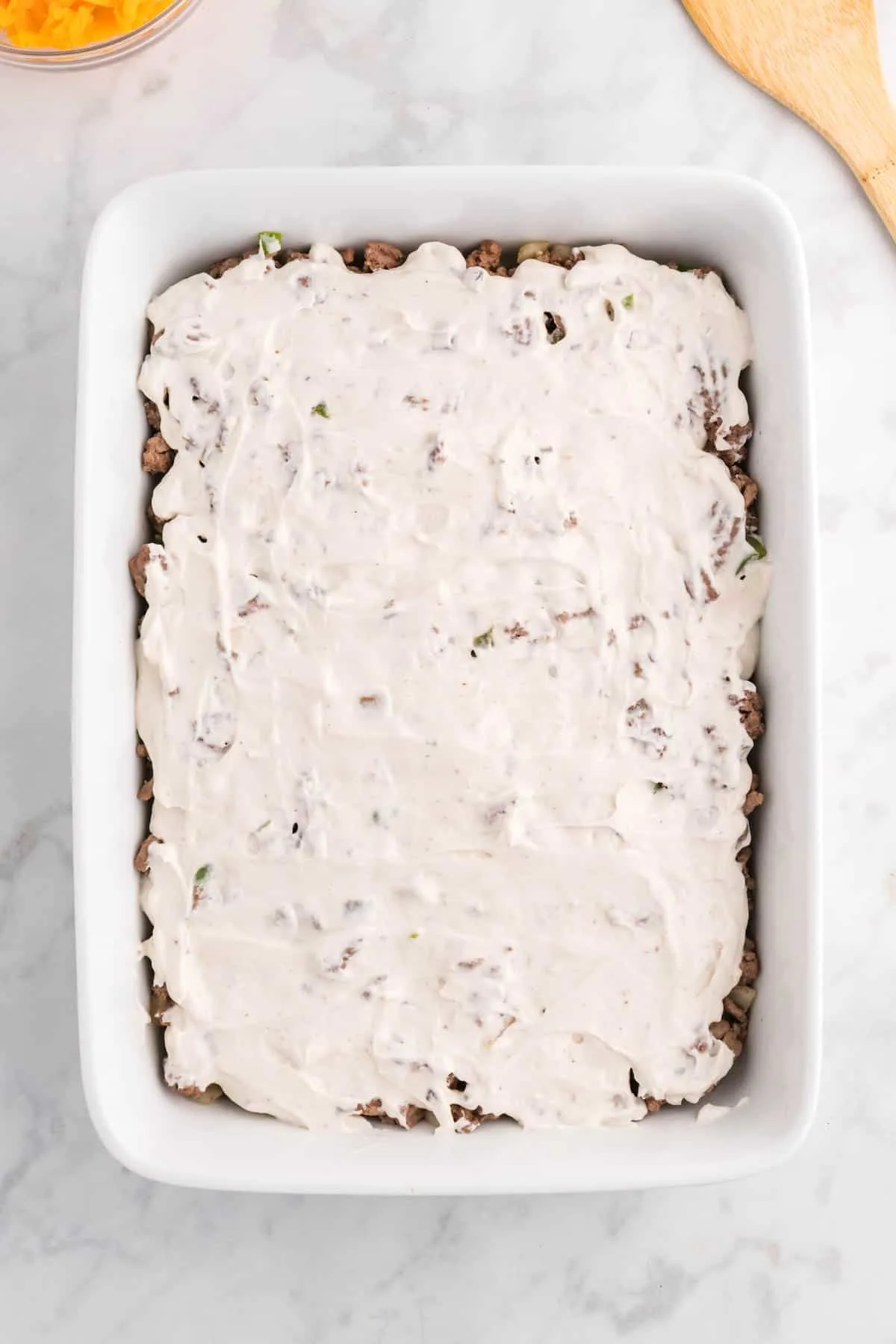 sour cream and cream of mushroom soup mixture spread over ground beef in a baking dish