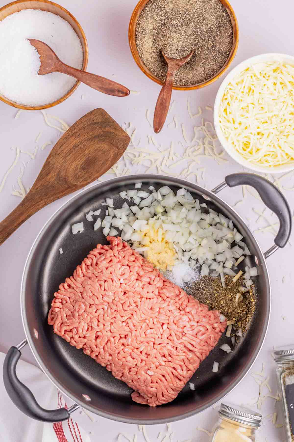 raw ground beef, diced onions and seasonings in a skillet