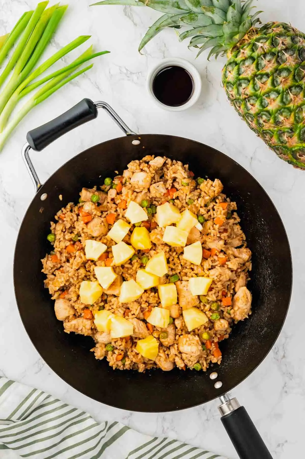 pineapple chunks added to skillet with chicken fried rice