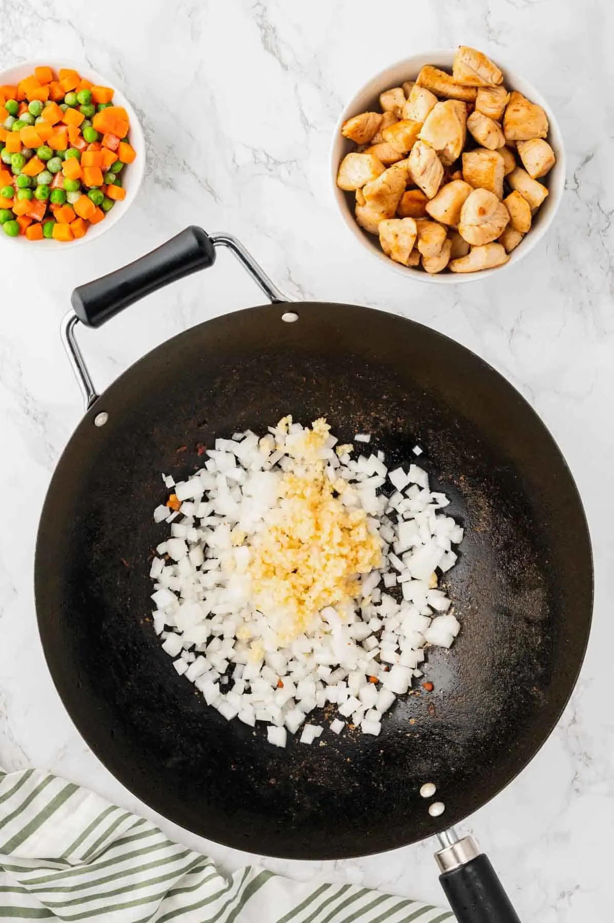 diced onion and minced garlic cooking in a wok