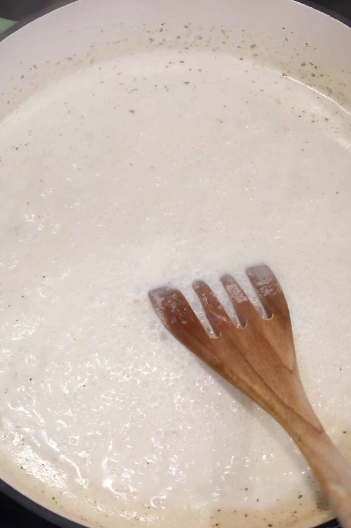 alfredo sauce simmering in a skillet