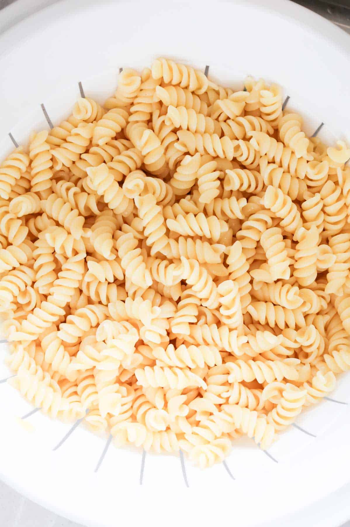 cooked rotini noodles in a colander