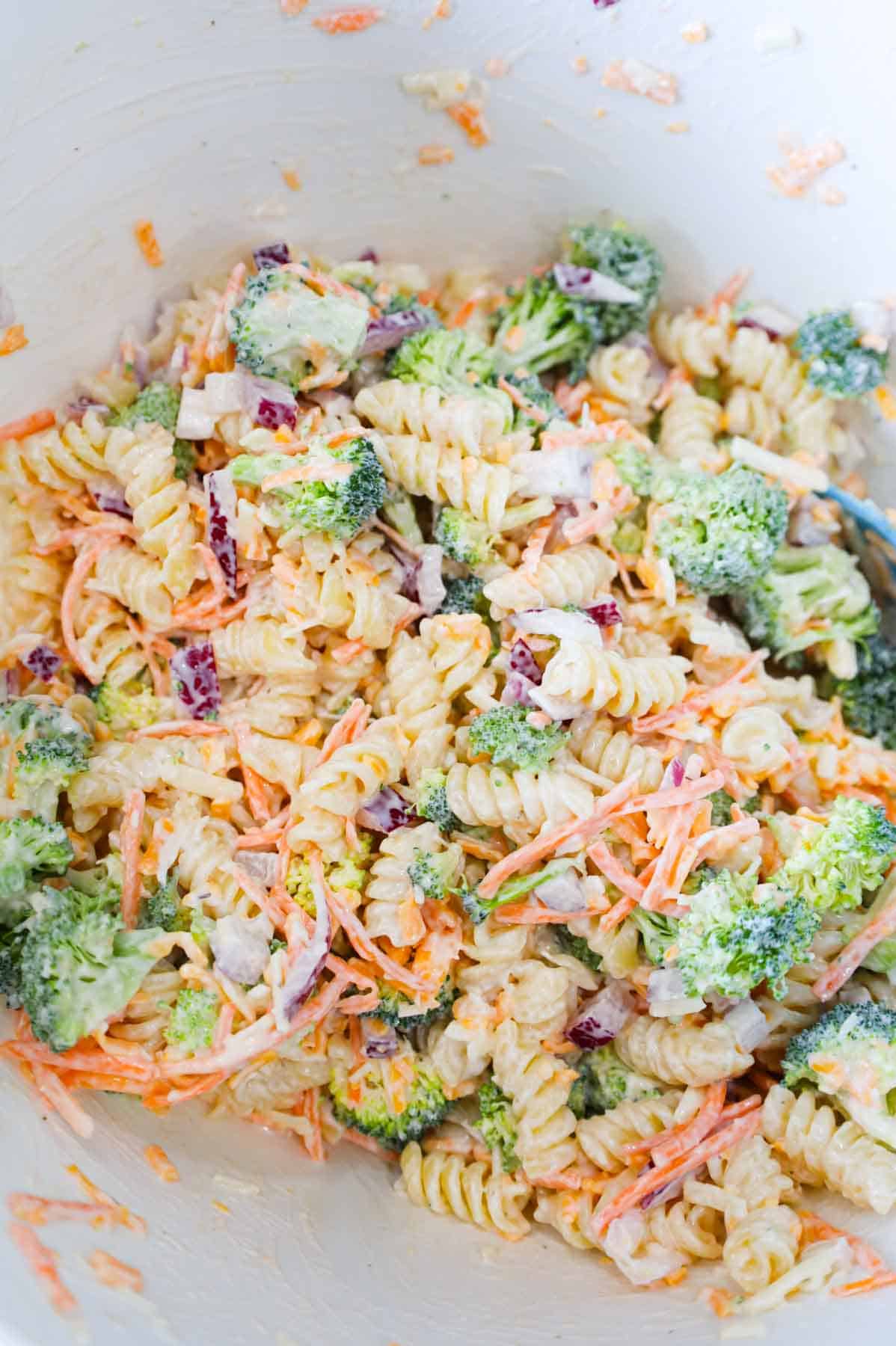 broccoli salad in a mixing bowl after being tossed with dressing