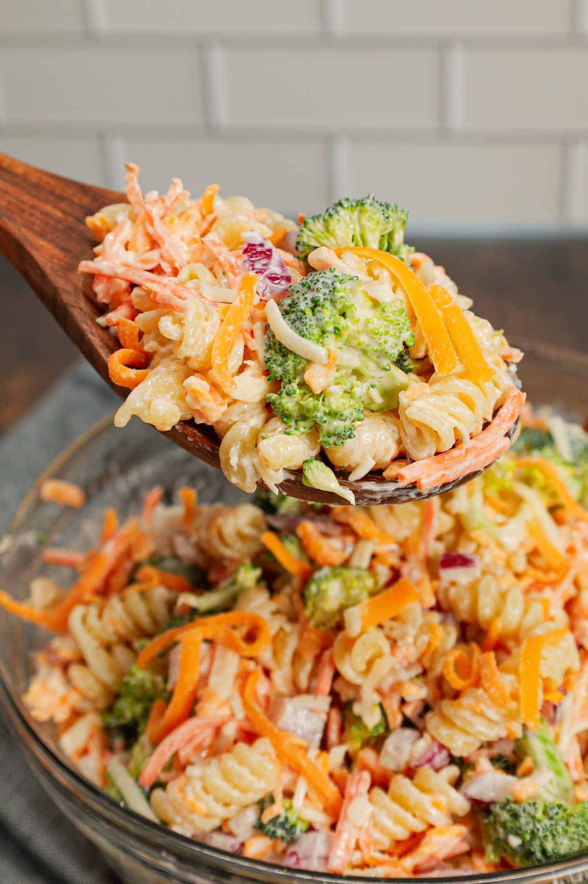 Broccoli Cheddar Pasta Salad is a tasty cold side dish recipe loaded with rotini pasta, broccoli florets, red onions, shredded carrots, cheddar cheese and parmesan all tossed in a mayo and ranch dressing mixture.