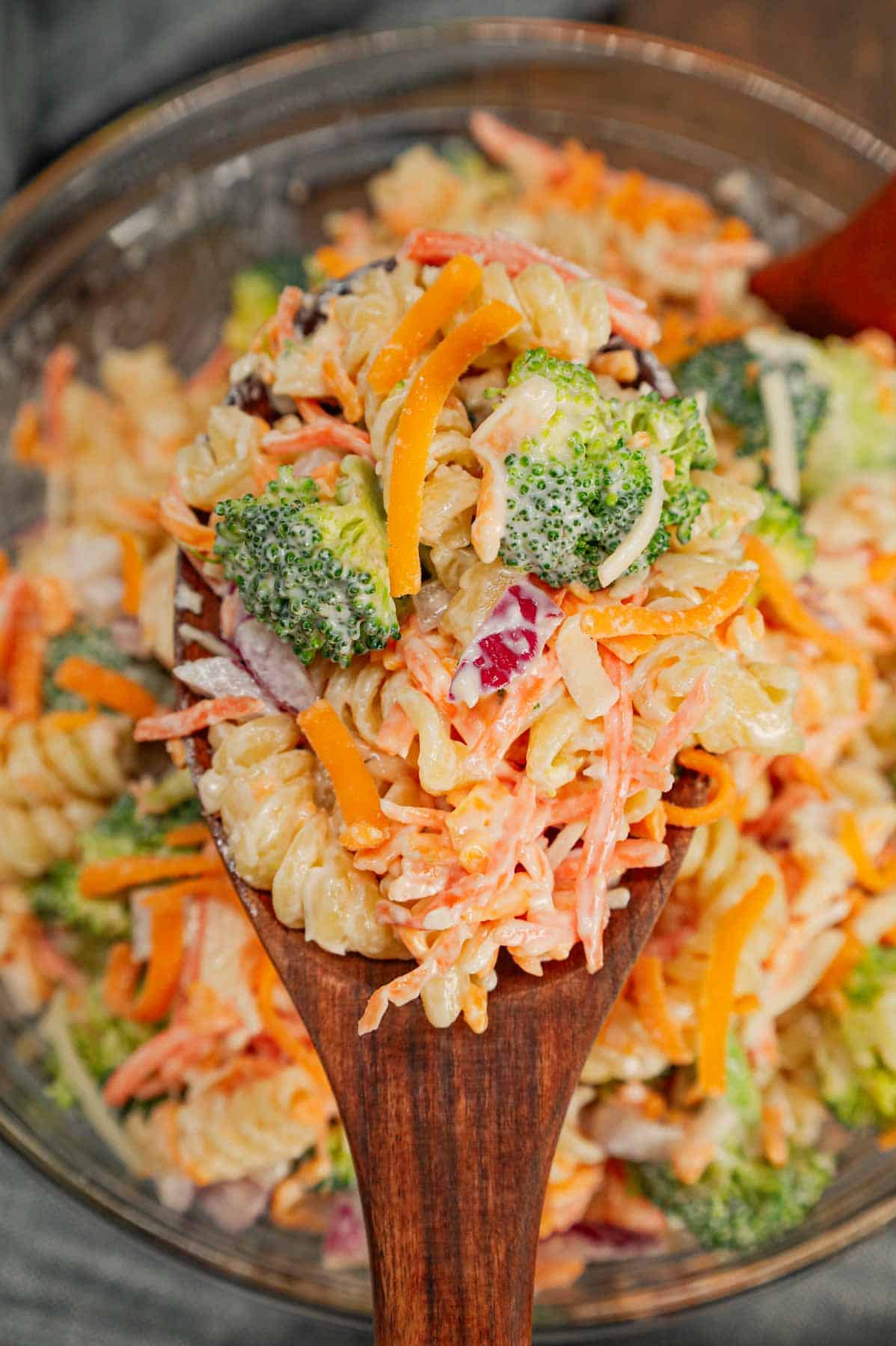 Broccoli Cheddar Pasta Salad is a tasty cold side dish recipe loaded with rotini pasta, broccoli florets, red onions, shredded carrots, cheddar cheese and parmesan all tossed in a mayo and ranch dressing mixture.