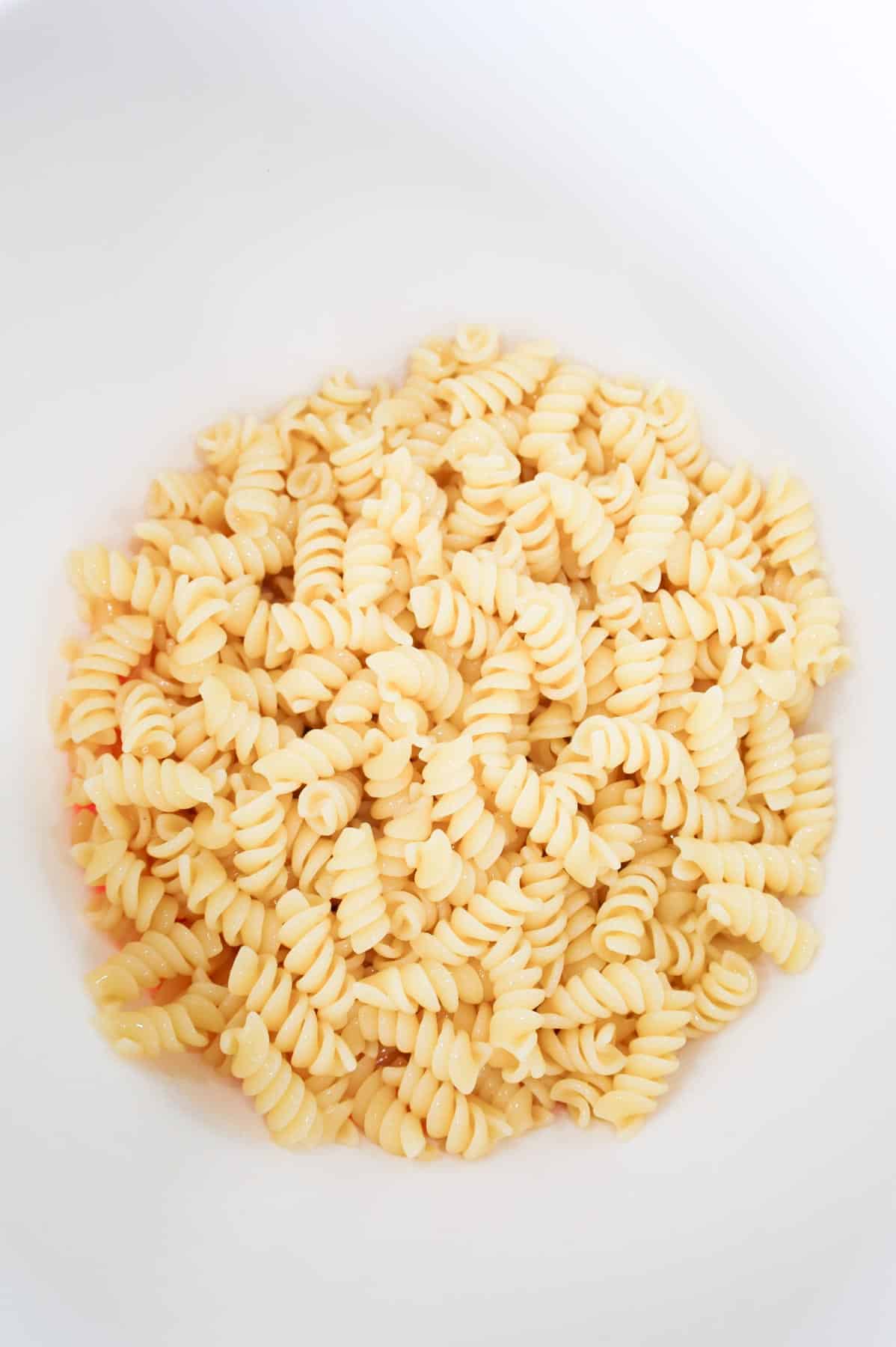 cooked rotini noodles in a large mixing bowl