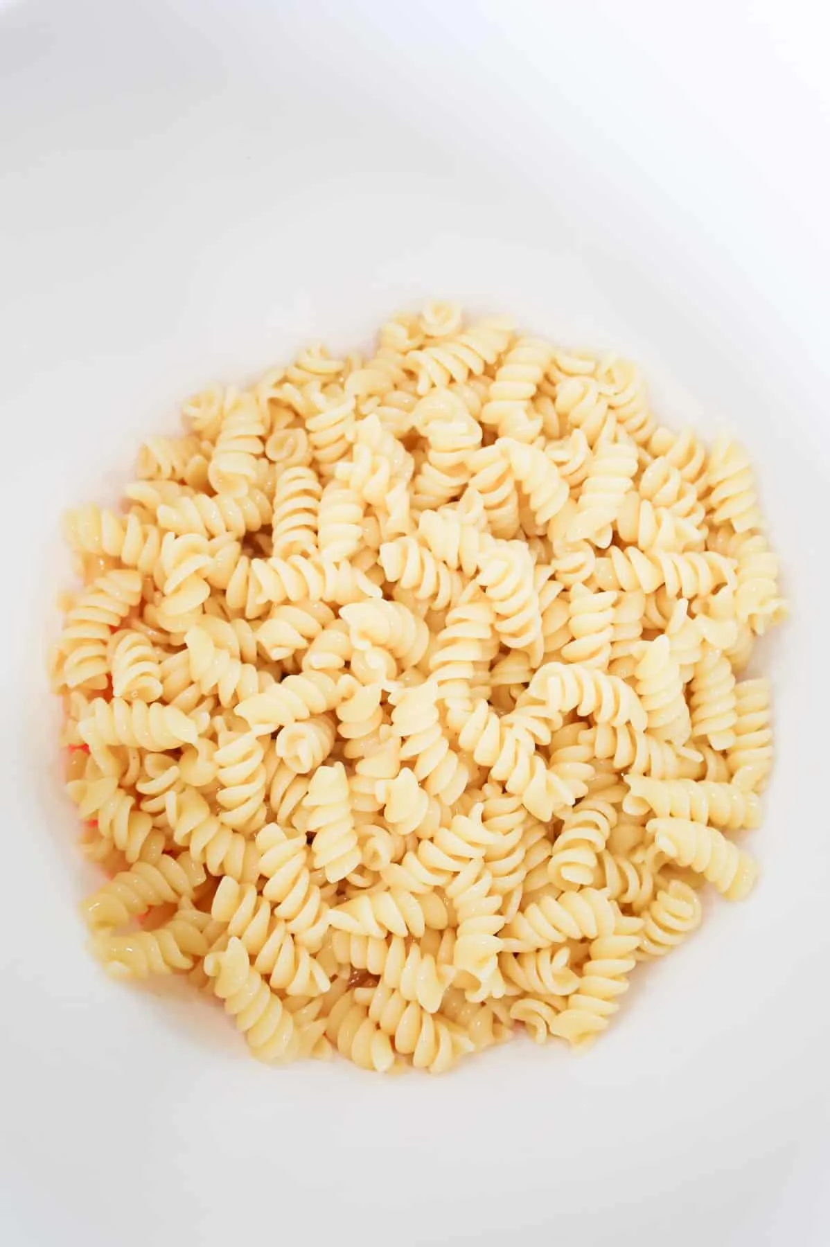 cooked rotini noodles in a large mixing bowl