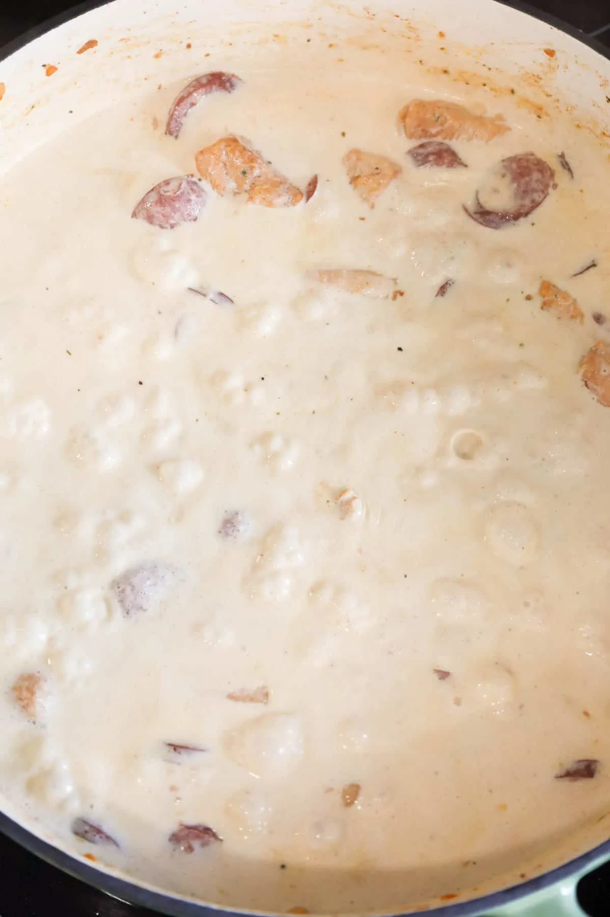 bringing cream sauce to a simmer in a skillet