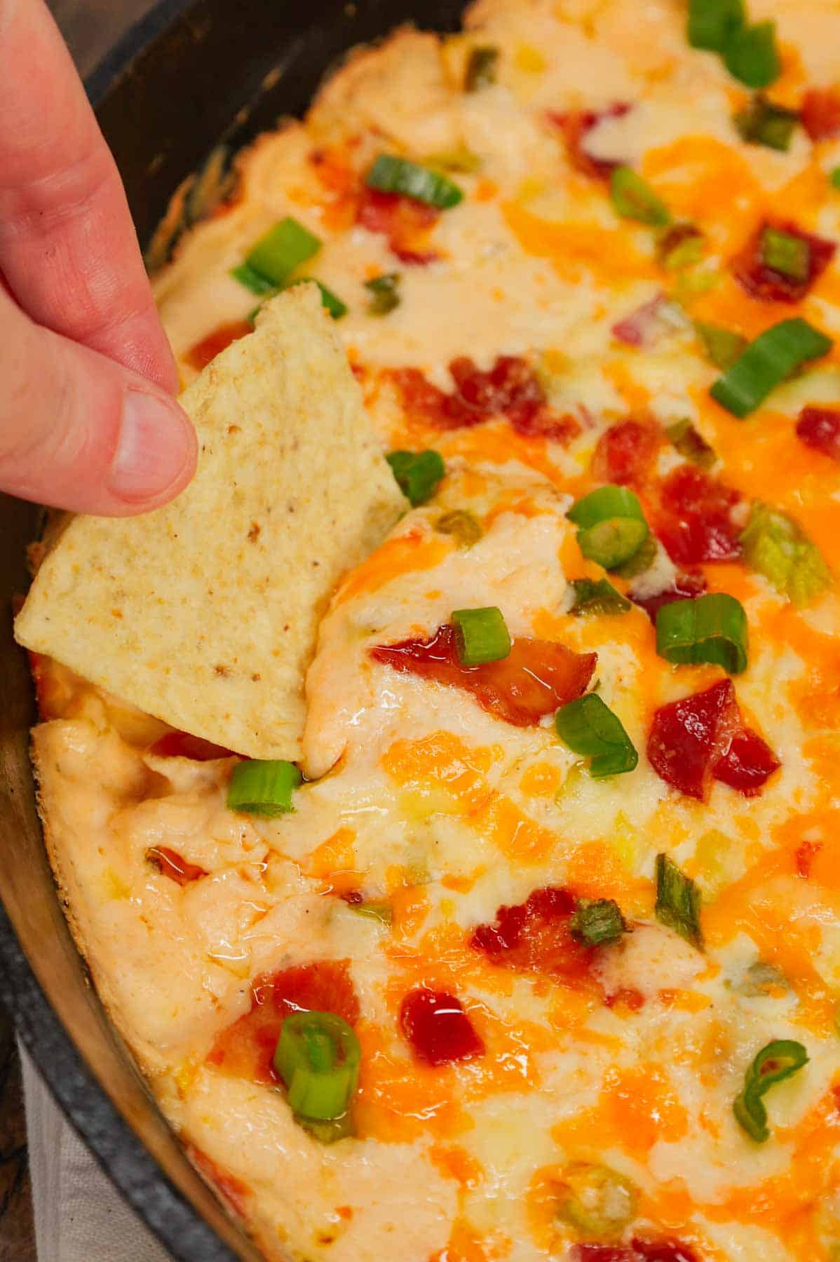 Cracked Out Corn Dip is a delicious hot dip recipe loaded with cream cheese, corn, sour cream, ranch dressing mix, bacon, green onions, cheddar cheese and mozzarella cheese.