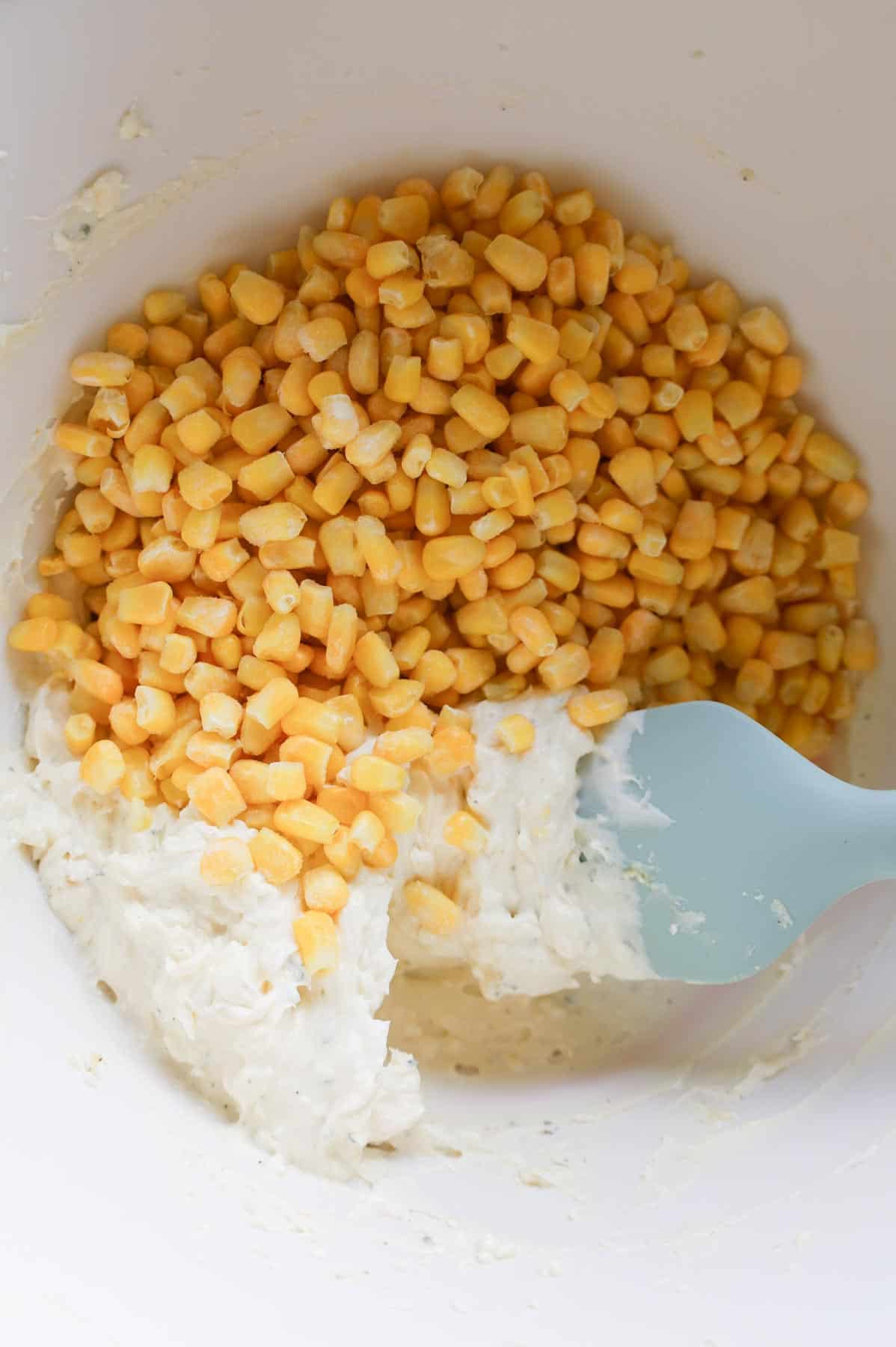 corn kernels on top of cream cheese mixture in a bowl
