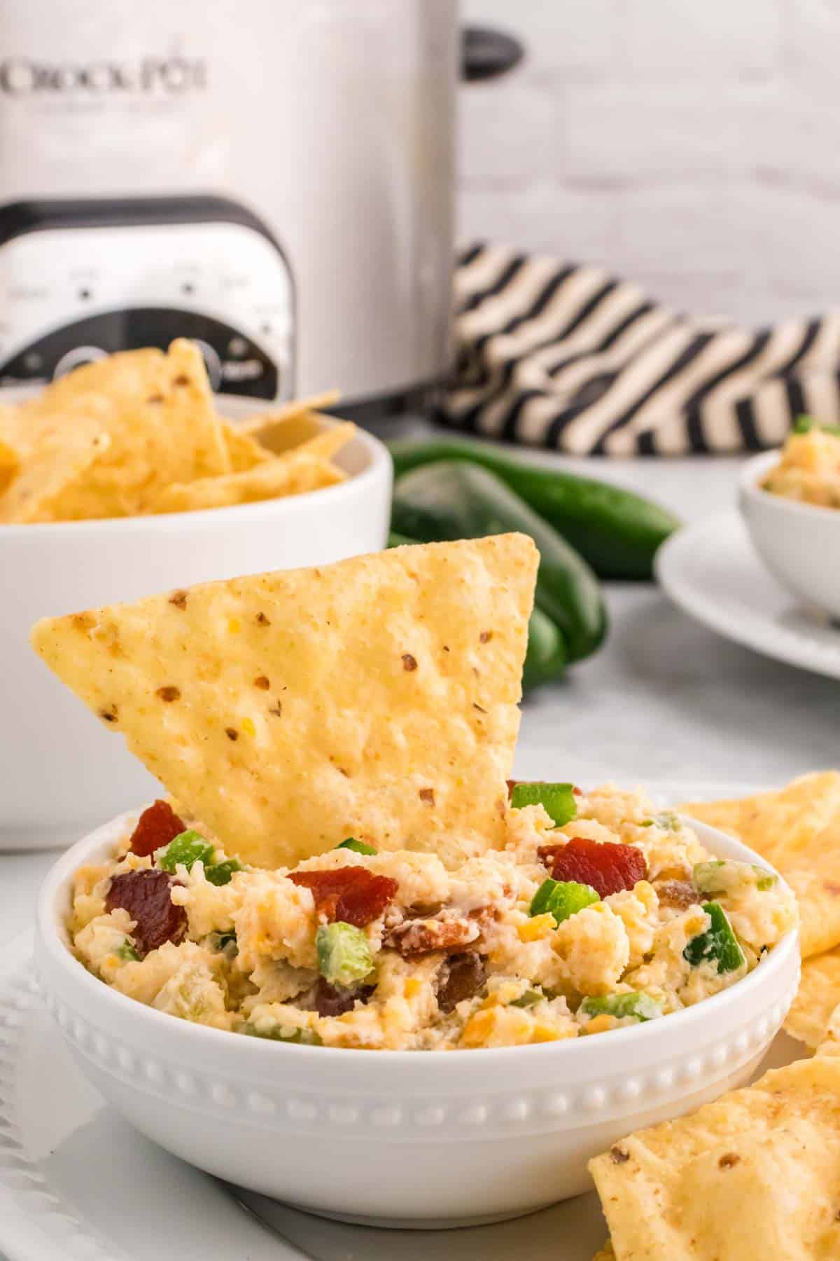 Crock Pot Jalapeno Popper Dip is a delicious hot dip recipe loaded with cream cheese, cheddar, Monterey Jack, mayo, sour cream, jalapenos, green chilies, parmesan, panko bread crumbs and bacon.