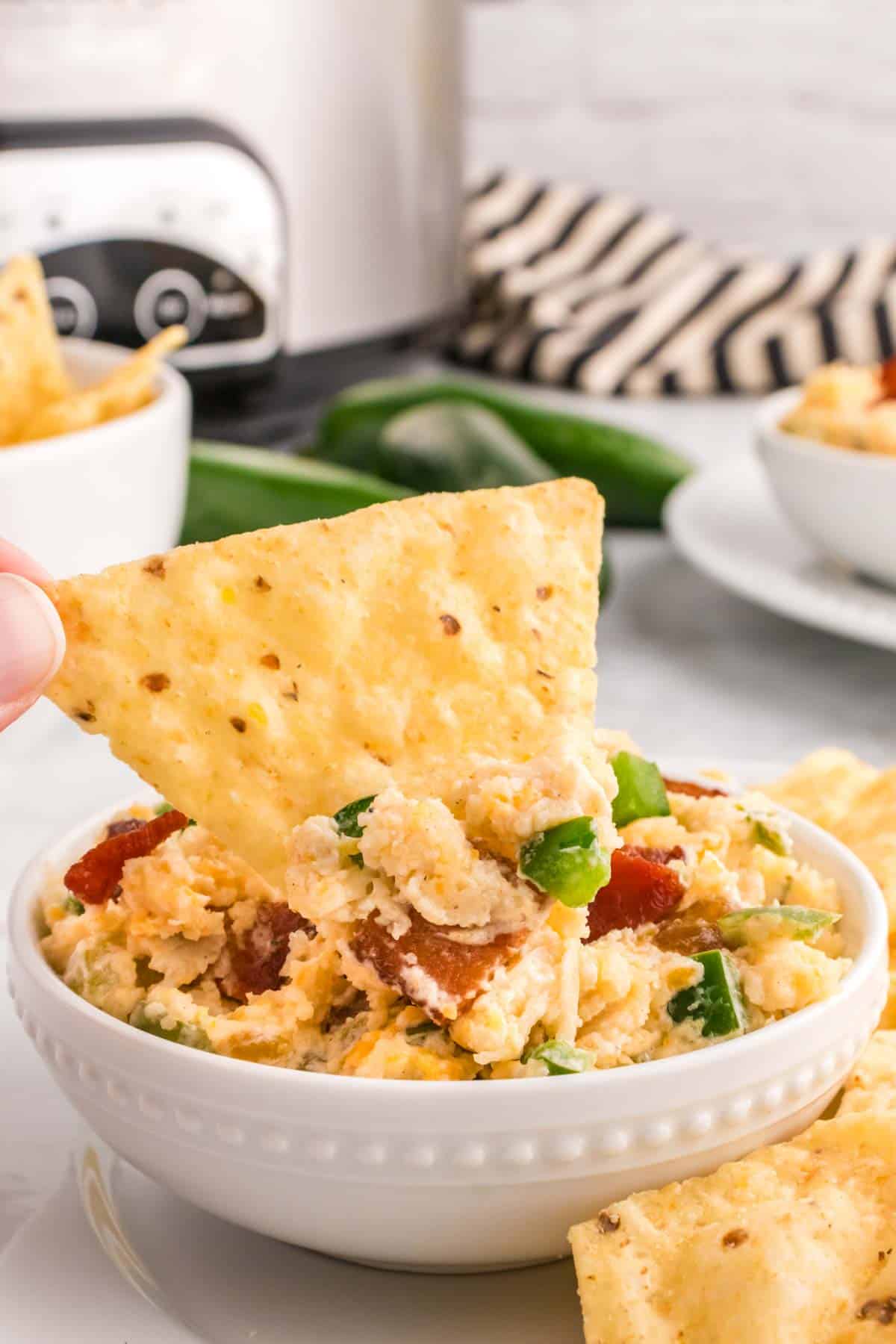 Crock Pot Jalapeno Popper Dip is a delicious hot dip recipe loaded with cream cheese, cheddar, Monterey Jack, mayo, sour cream, jalapenos, green chilies, parmesan, panko bread crumbs and bacon.