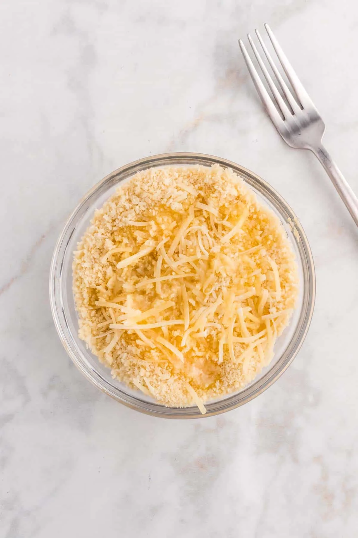 shredded parmesan, melted butter and breadcrumbs in a bowl