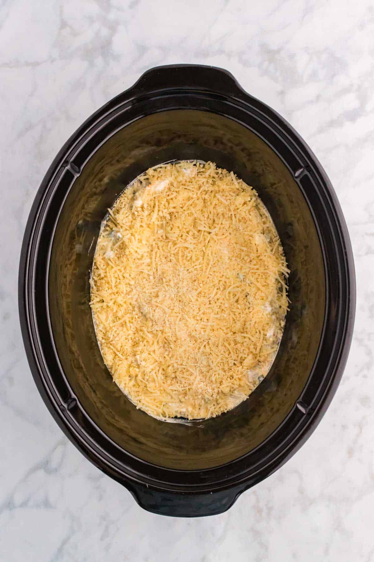 parmesan bread crumb mixture on top of jalapeno popper dip in a crock pot before cooking