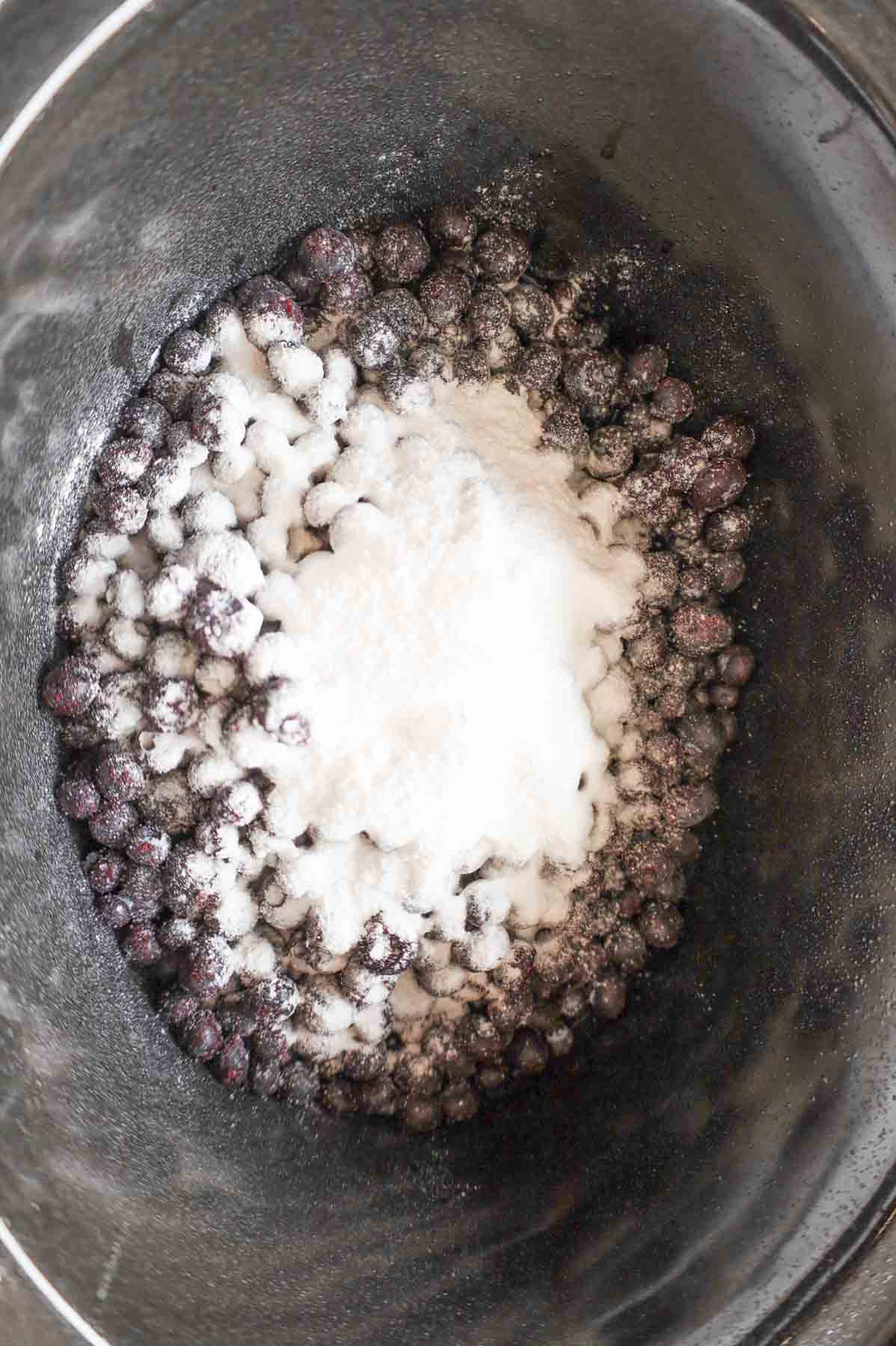 lemon pudding mix and sugar on top of blueberries in a crock pot