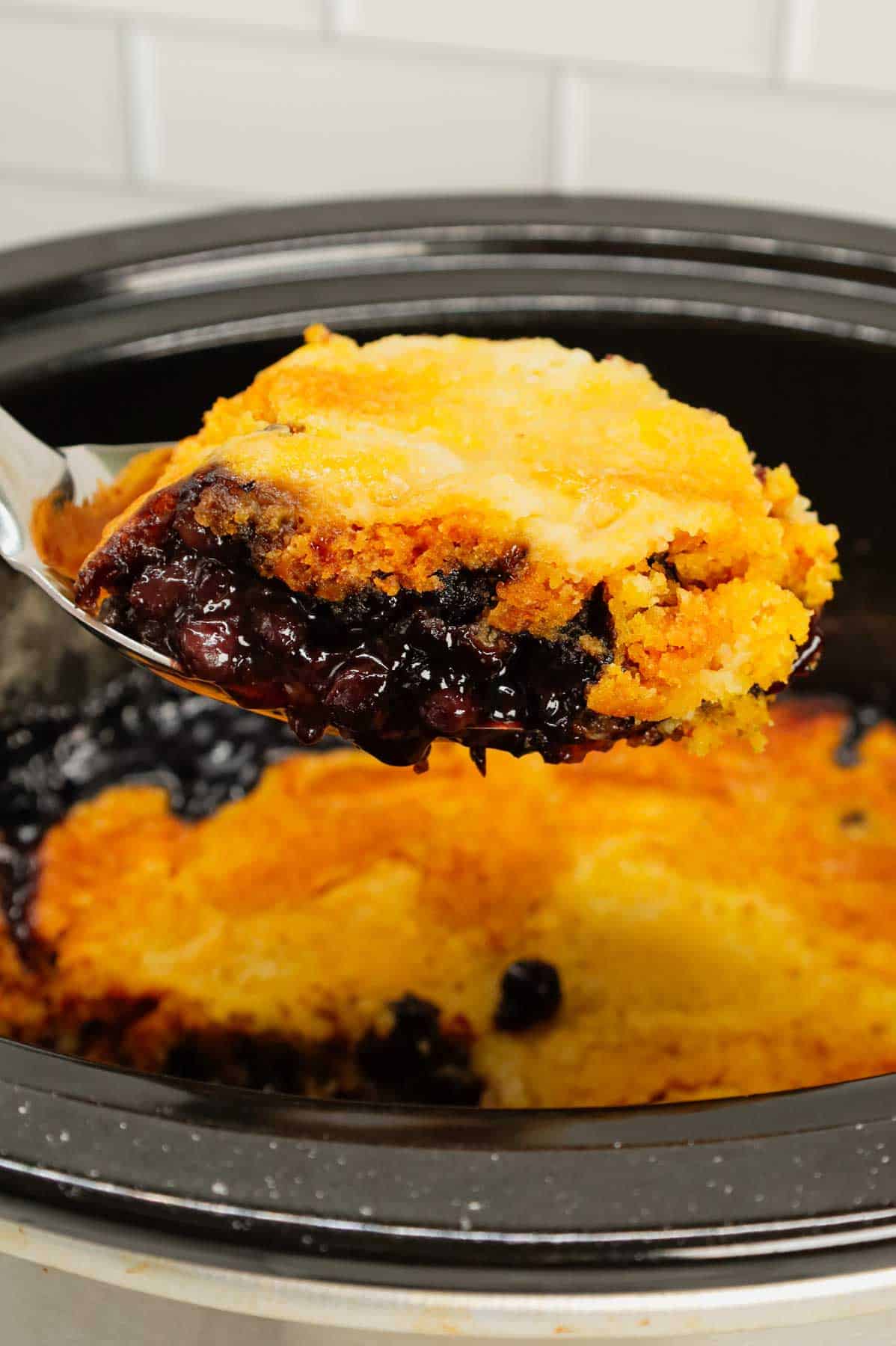 Crock Pot Lemon Blueberry Cobbler is an easy slow cooker dessert recipe using frozen blueberries, lemon pudding mix, sugar, boxed lemon cake mix and butter.