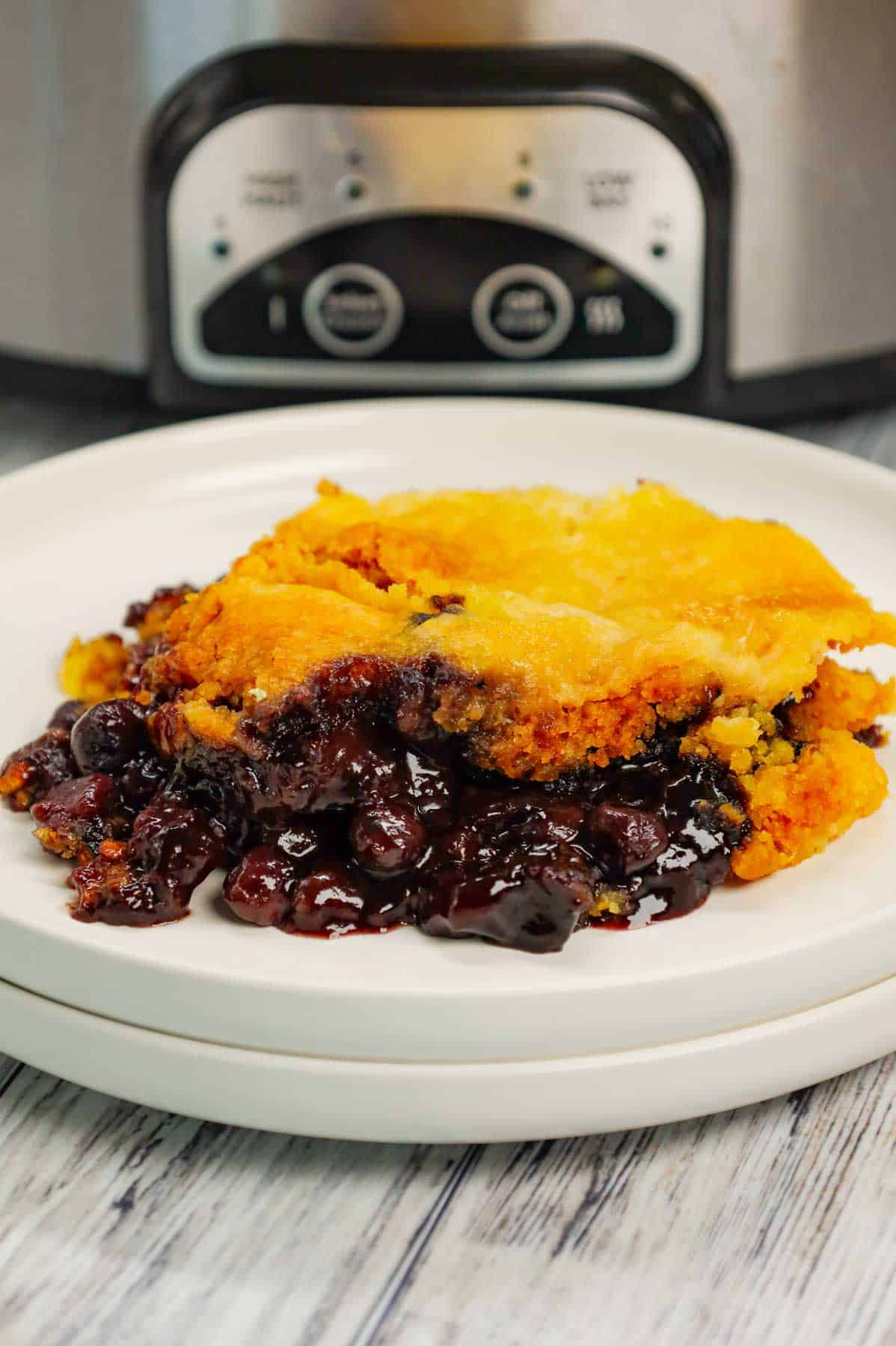 Crock Pot Lemon Blueberry Cobbler is an easy slow cooker dessert recipe using frozen blueberries, lemon pudding mix, sugar, boxed lemon cake mix and butter.