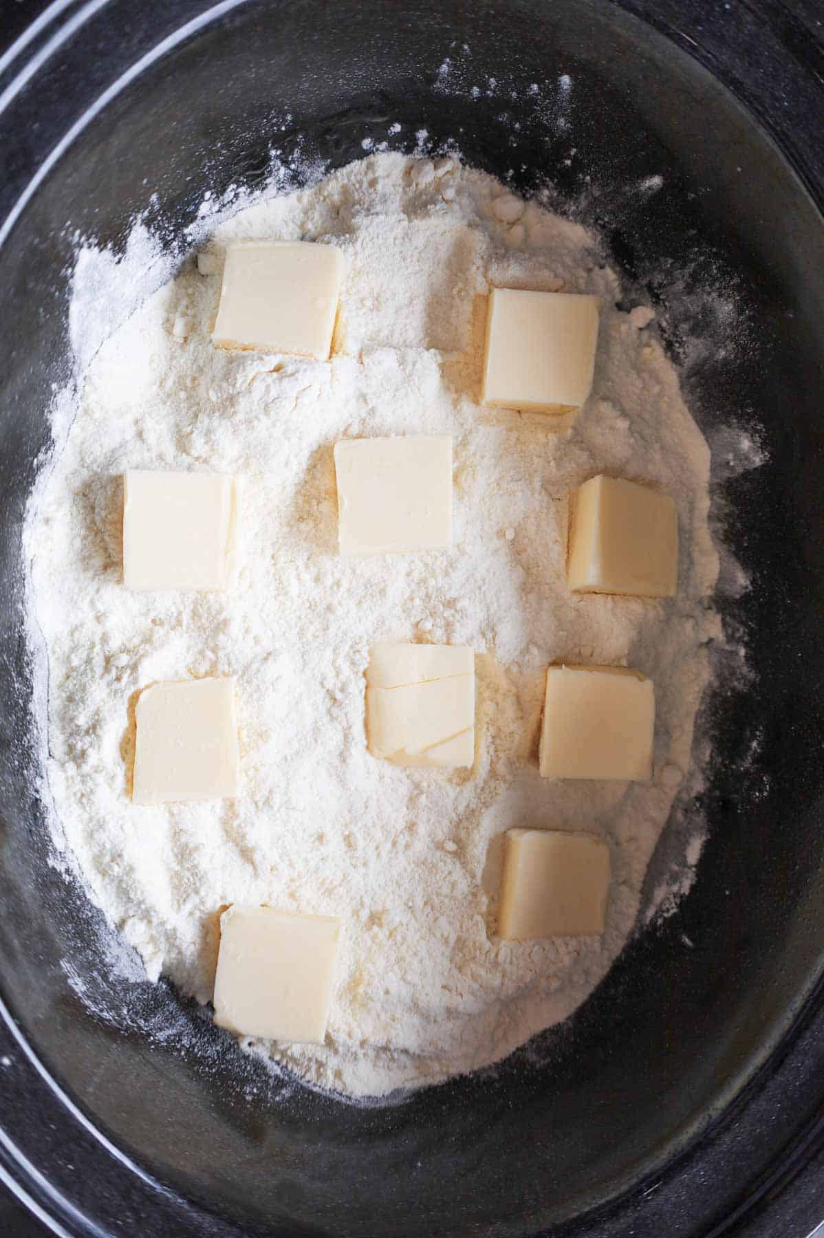 squares of butter on top of lemon cake mix in a crock pot
