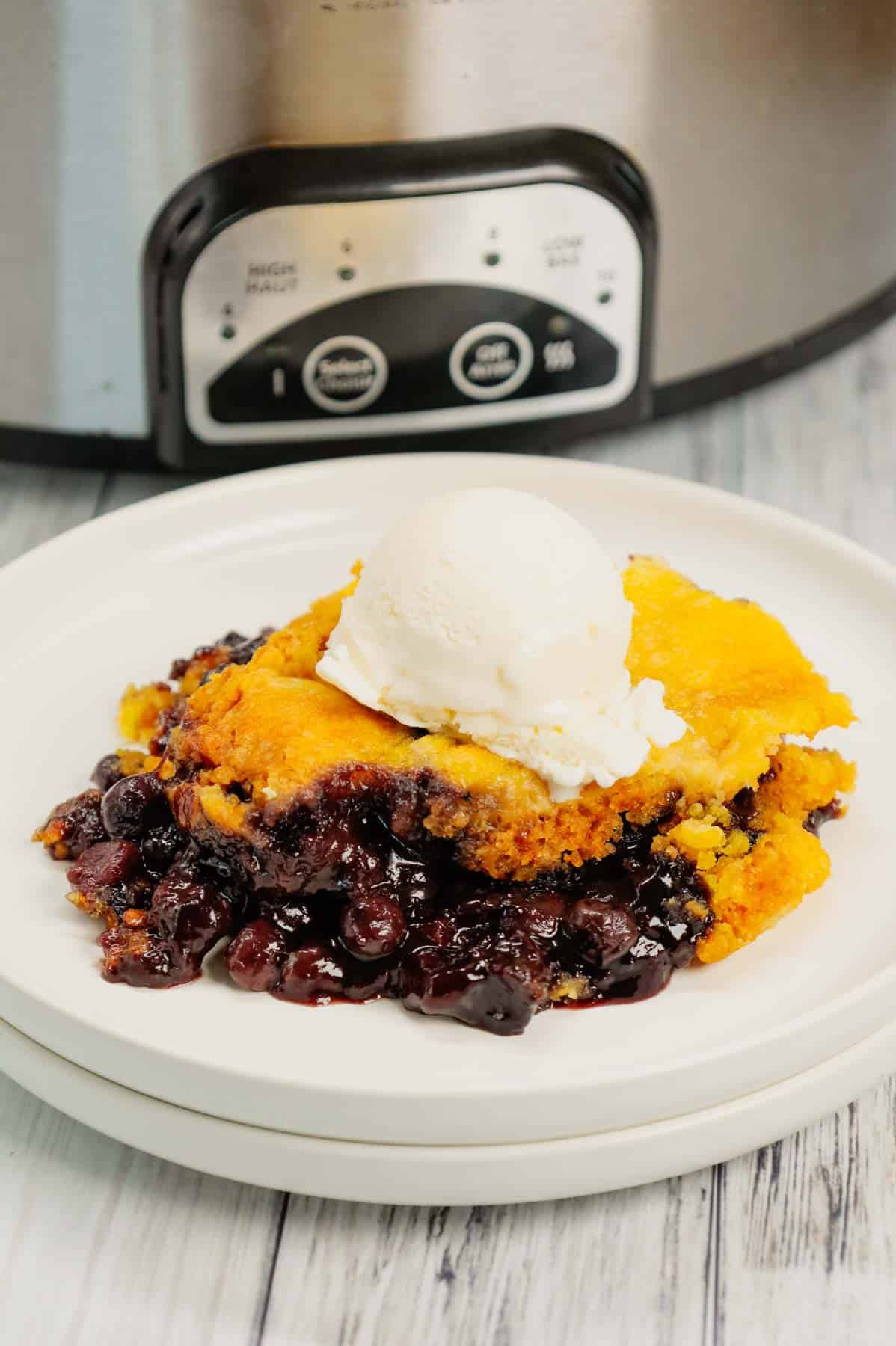 Crock Pot Lemon Blueberry Cobbler is an easy slow cooker dessert recipe using frozen blueberries, lemon pudding mix, sugar, boxed lemon cake mix and butter.