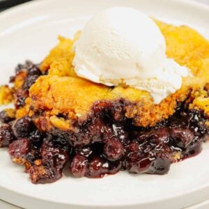 Crock Pot Lemon Blueberry Cobbler is an easy slow cooker dessert recipe using frozen blueberries, lemon pudding mix, sugar, boxed lemon cake mix and butter.