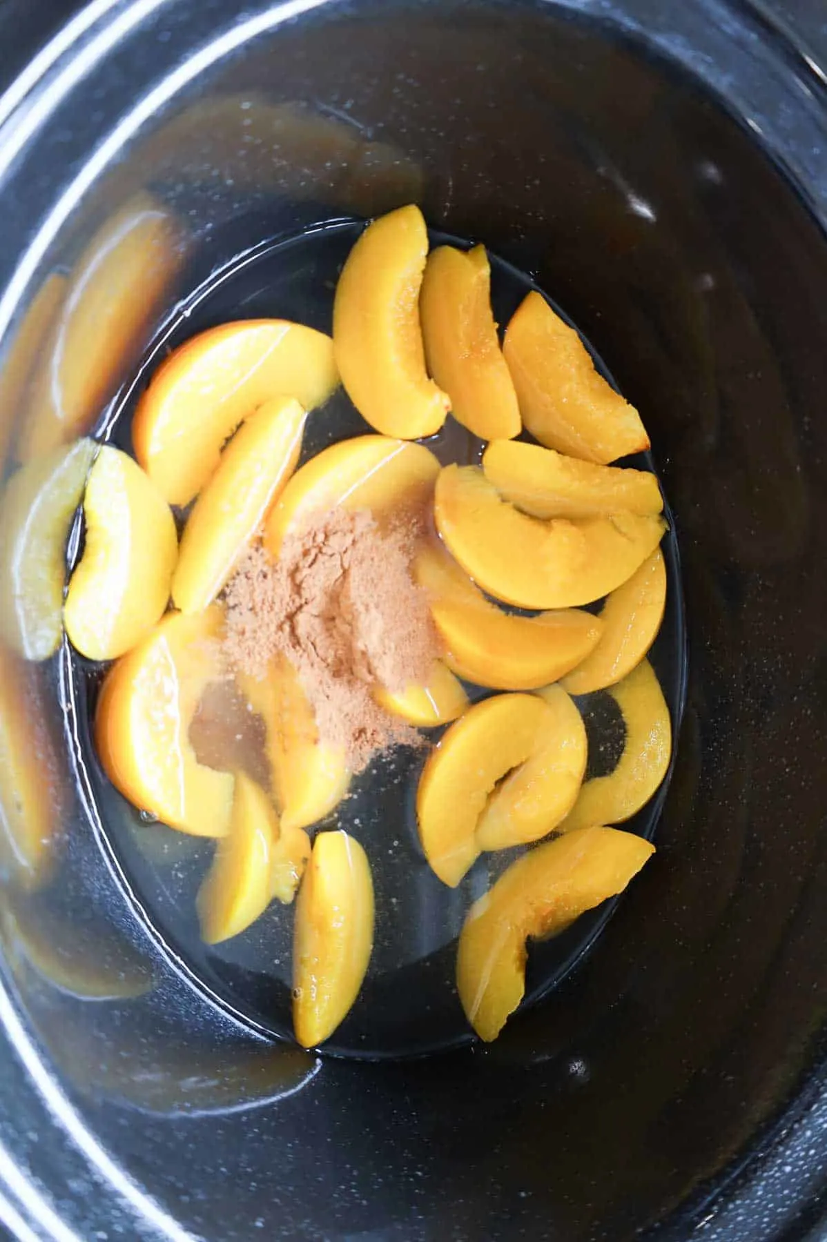 cinnamon on top of canned peach slices in a crock pot