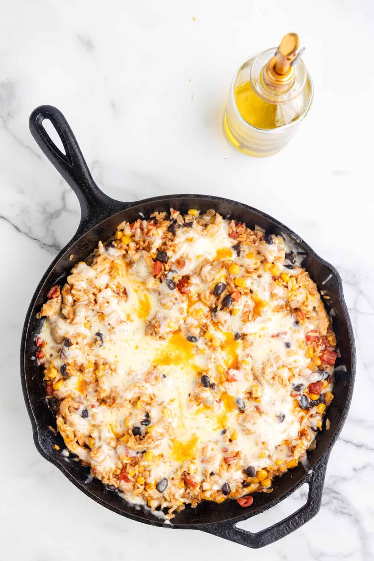 One Pan Cheesy Taco Chicken and Rice is an easy stove top dinner recipe loaded with chicken thigh chunks, Rotel, corn, black beans, taco seasoning, rice and shredded cheese.