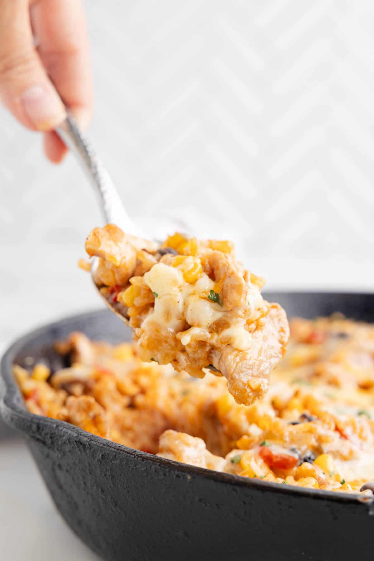 One Pan Cheesy Taco Chicken and Rice is an easy stove top dinner recipe loaded with chicken thigh chunks, Rotel, corn, black beans, taco seasoning, rice and shredded cheese.