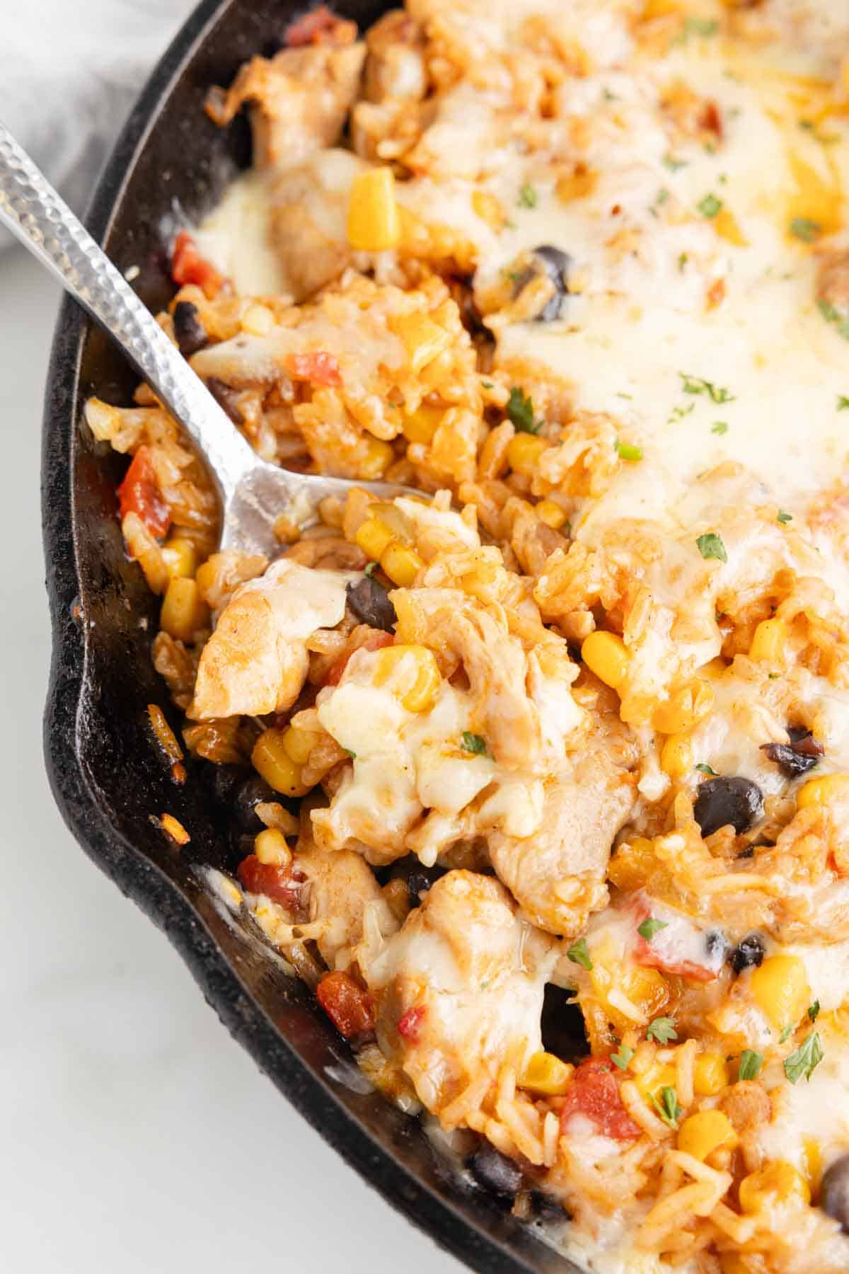 One Pan Cheesy Taco Chicken and Rice is an easy stove top dinner recipe loaded with chicken thigh chunks, Rotel, corn, black beans, taco seasoning, rice and shredded cheese.