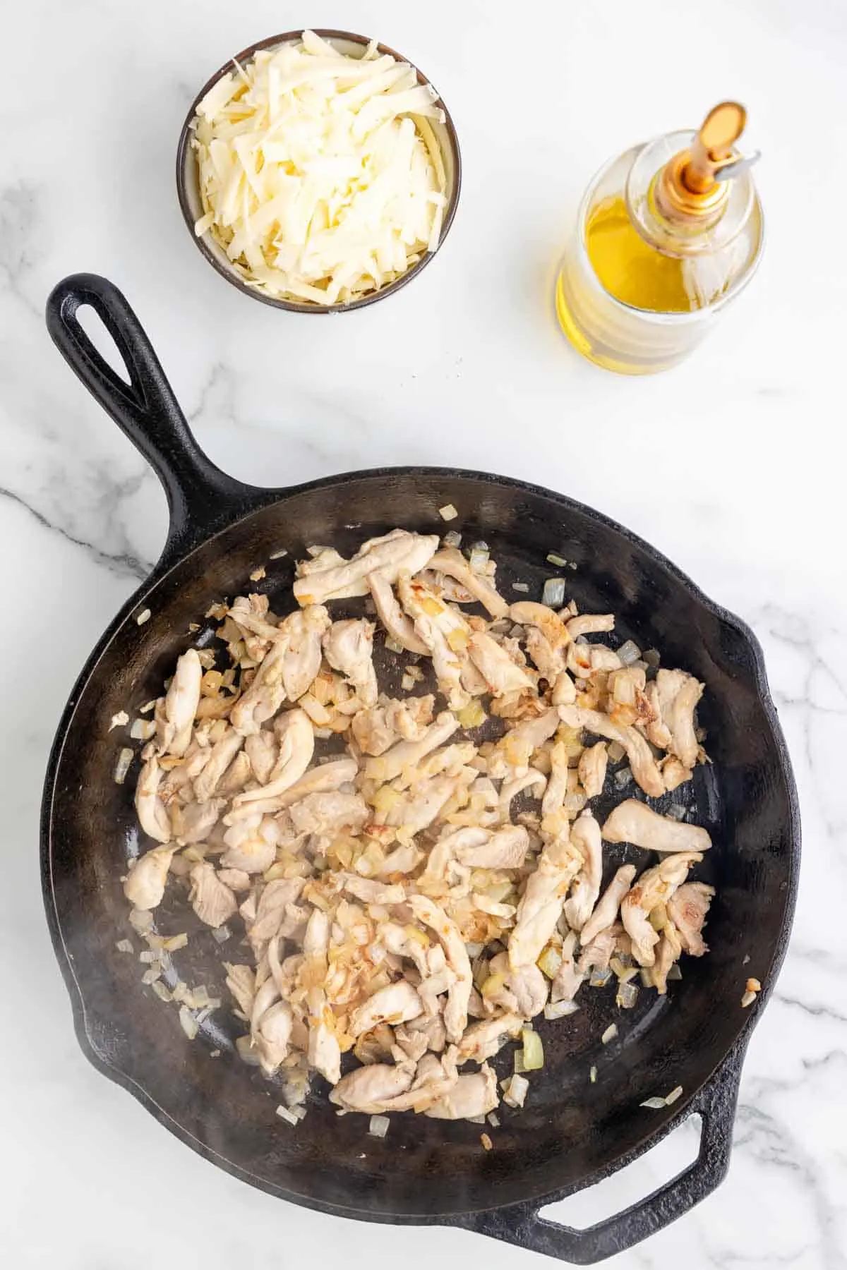 strips of chicken cooking in a skillet