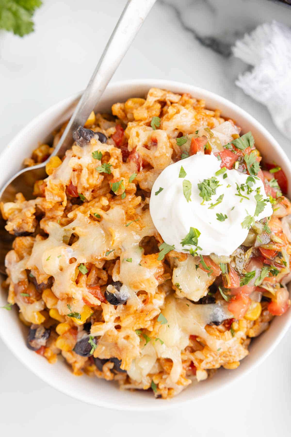 One Pan Cheesy Taco Chicken and Rice is an easy stove top dinner recipe loaded with chicken thigh chunks, Rotel, corn, black beans, taco seasoning, rice and shredded cheese.