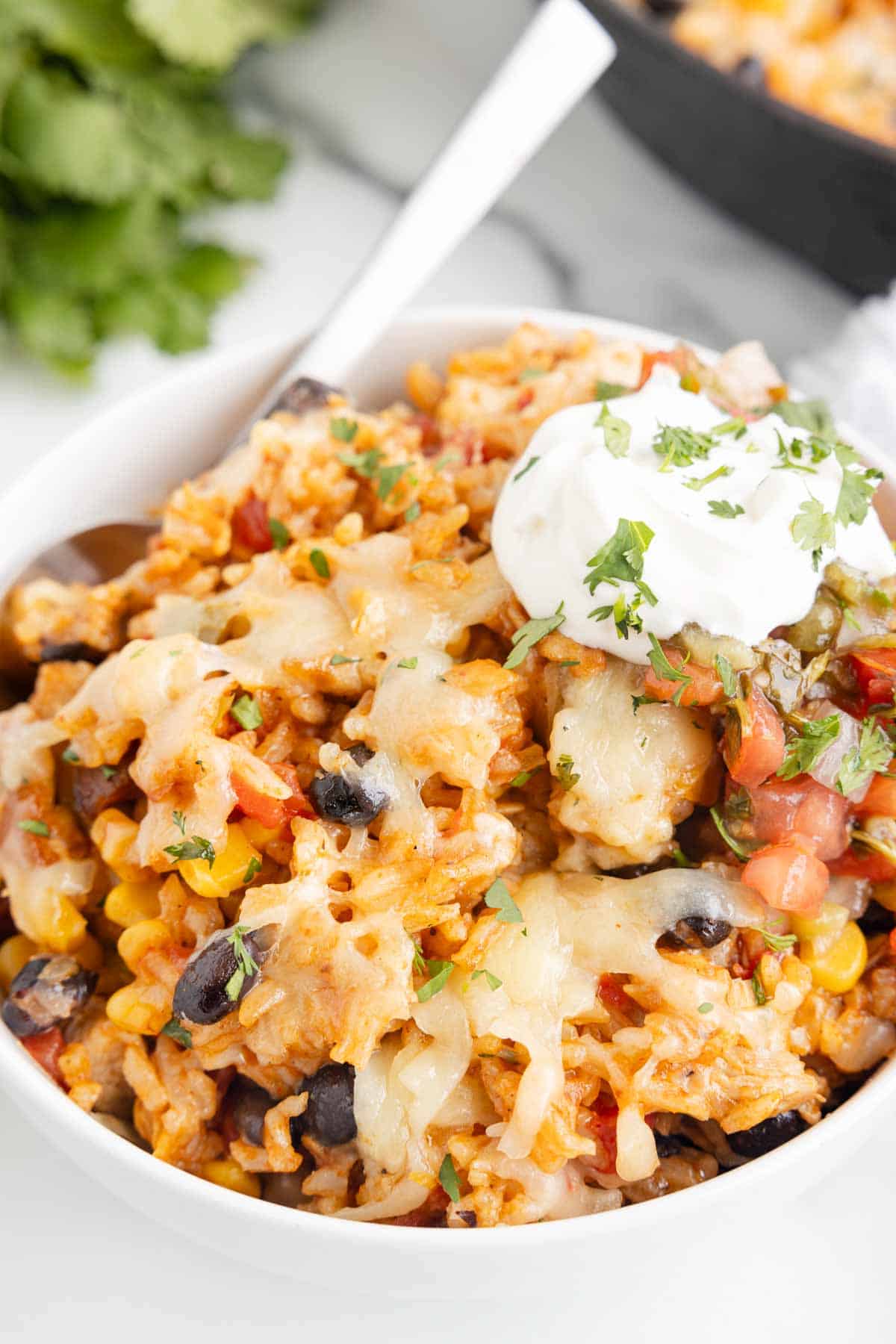 One Pan Cheesy Taco Chicken and Rice is an easy stove top dinner recipe loaded with chicken thigh chunks, Rotel, corn, black beans, taco seasoning, rice and shredded cheese.