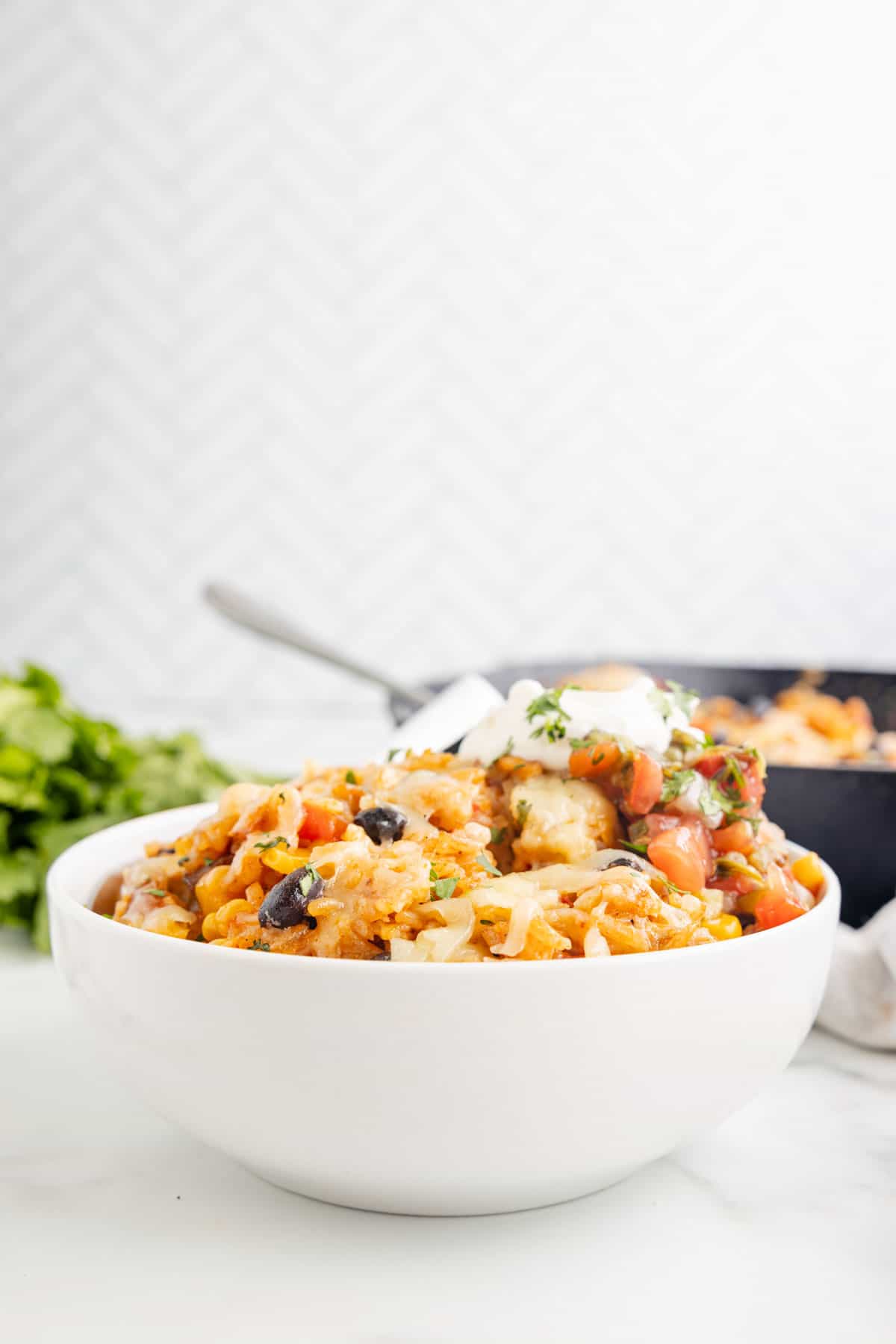 One Pan Cheesy Taco Chicken and Rice is an easy stove top dinner recipe loaded with chicken thigh chunks, Rotel, corn, black beans, taco seasoning, rice and shredded cheese.