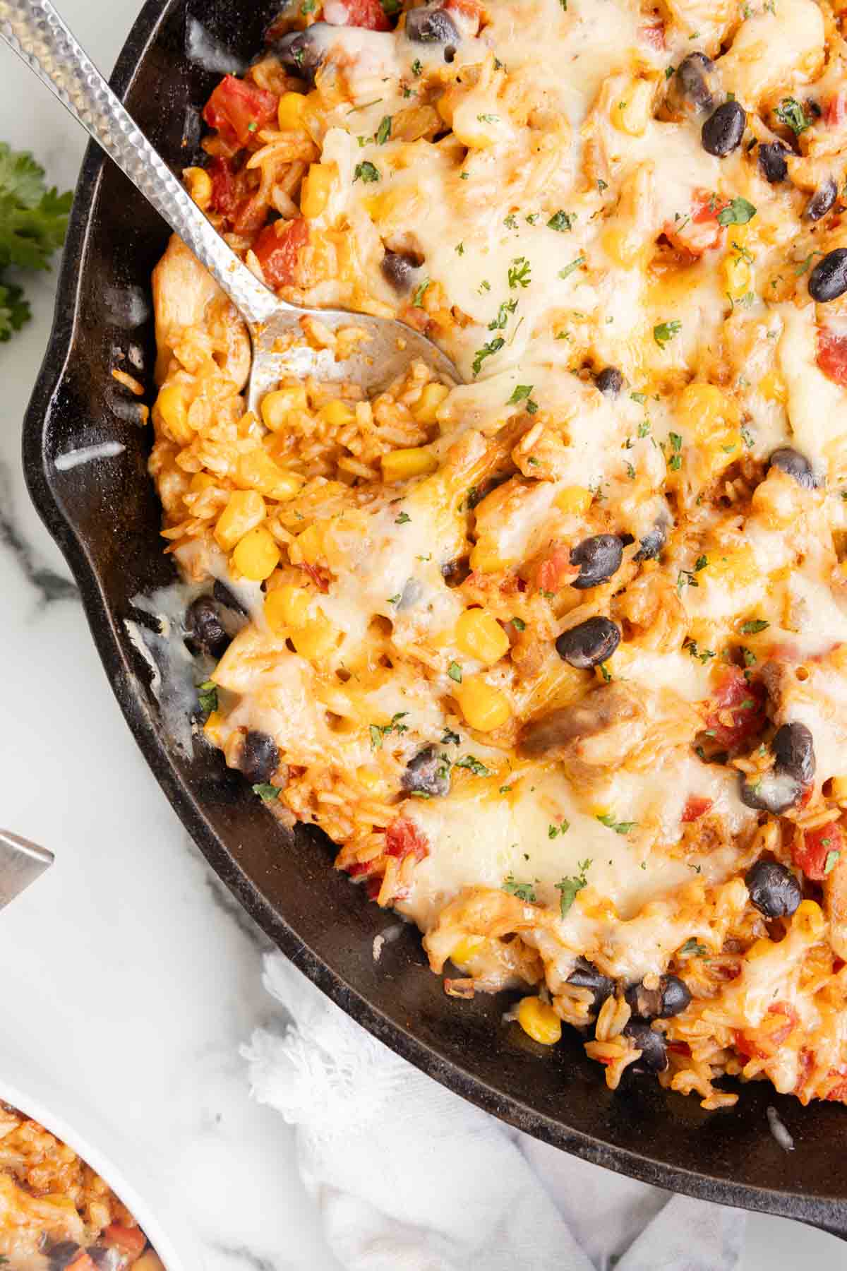 One Pan Cheesy Taco Chicken and Rice is an easy stove top dinner recipe loaded with chicken thigh chunks, Rotel, corn, black beans, taco seasoning, rice and shredded cheese.