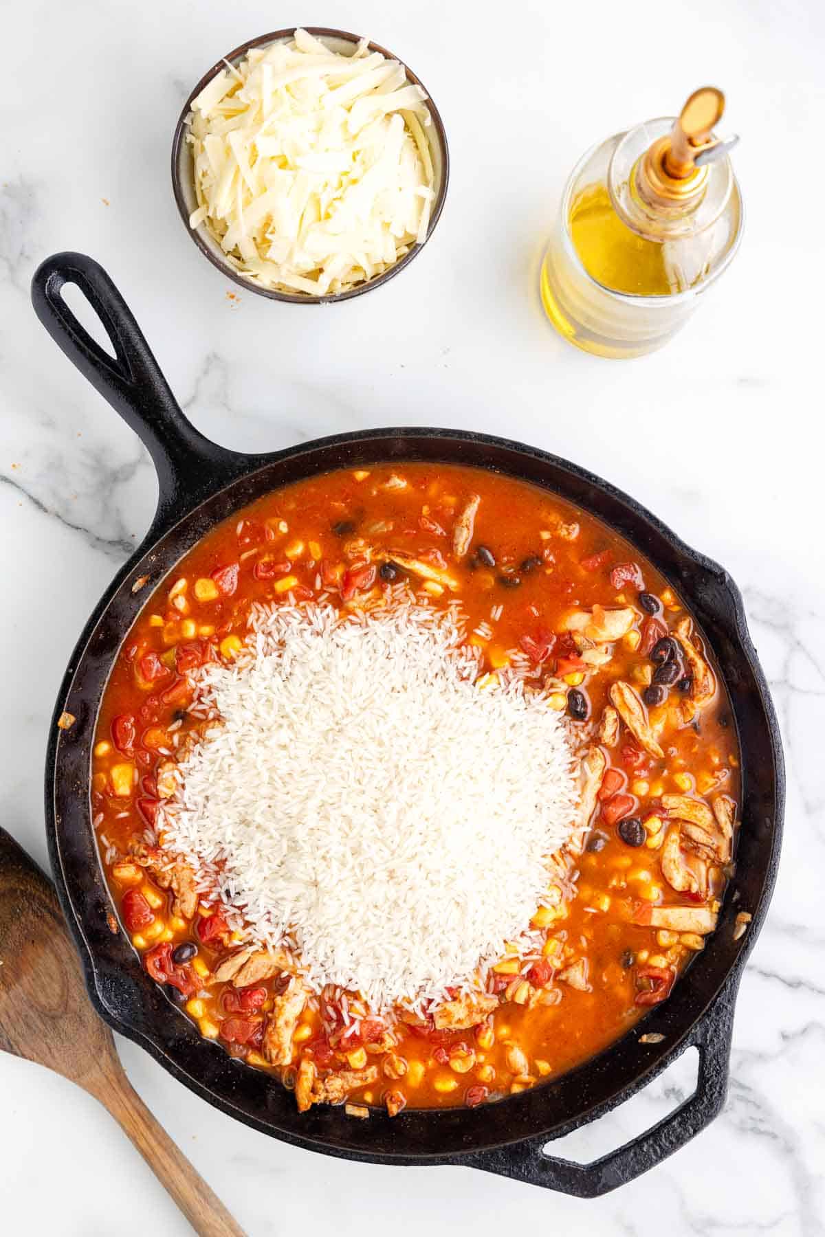 uncooked white rice added to skillet with taco chicken mixture.