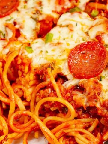 Pizza Baked Spaghetti is a hearty spaghetti recipe loaded with Italian sausage, pepperoni, green bell peppers, pizza sauce, marinara and mozzarella cheese.